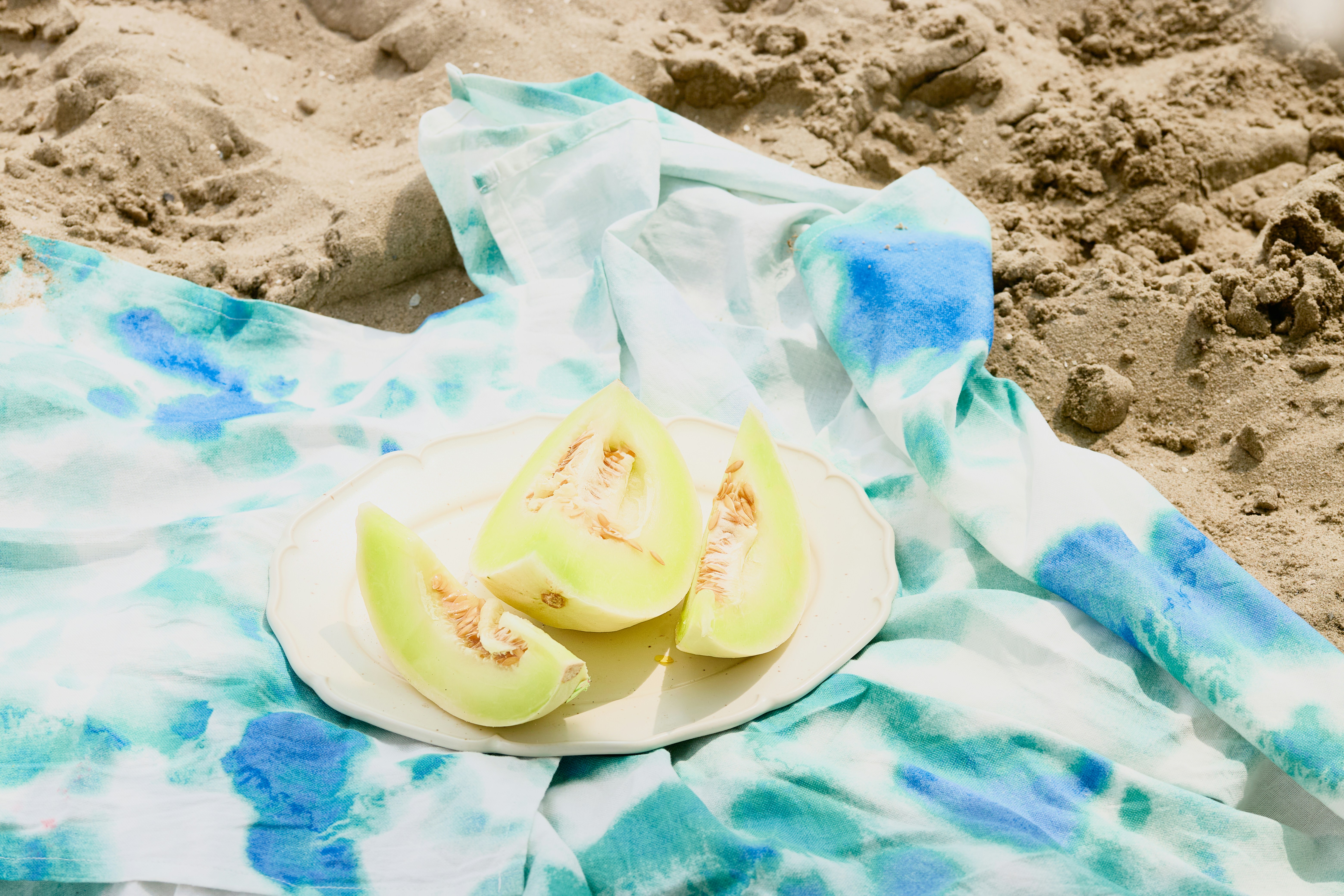 Melon slices on a plate at the beach.