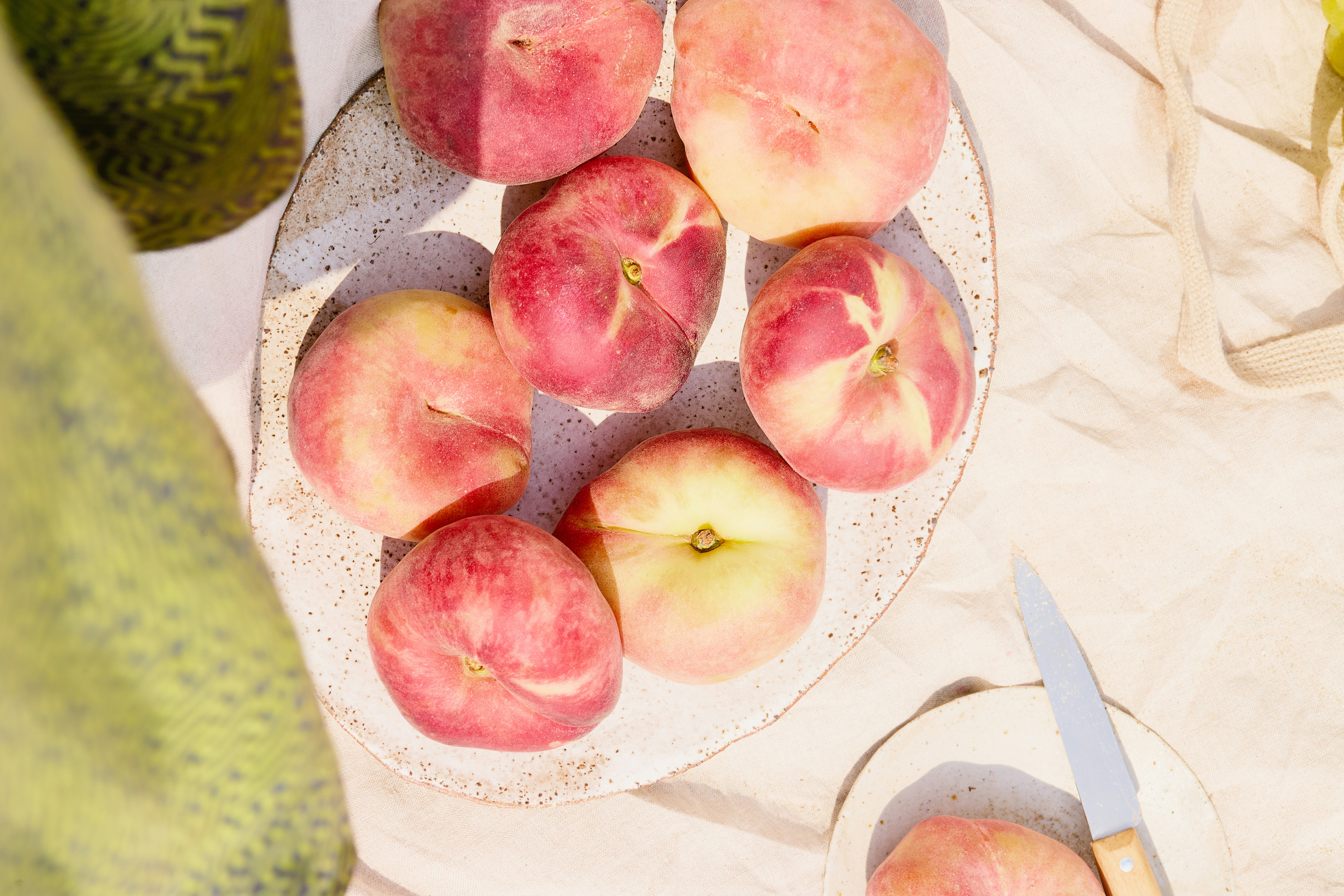 Fresh peaches rest on a plate, ready to eat.