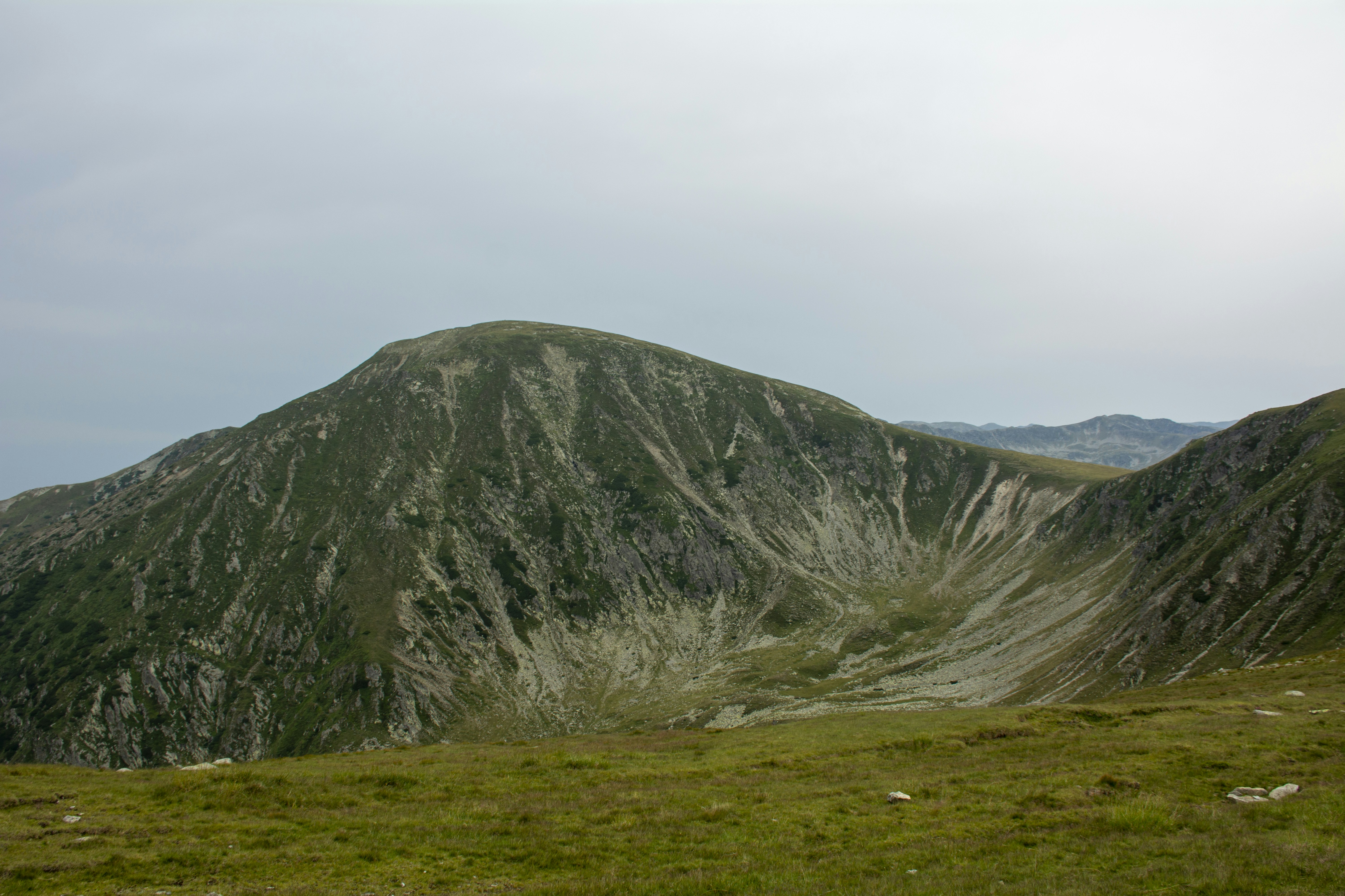 A rocky mountain dominates the grassy landscape.