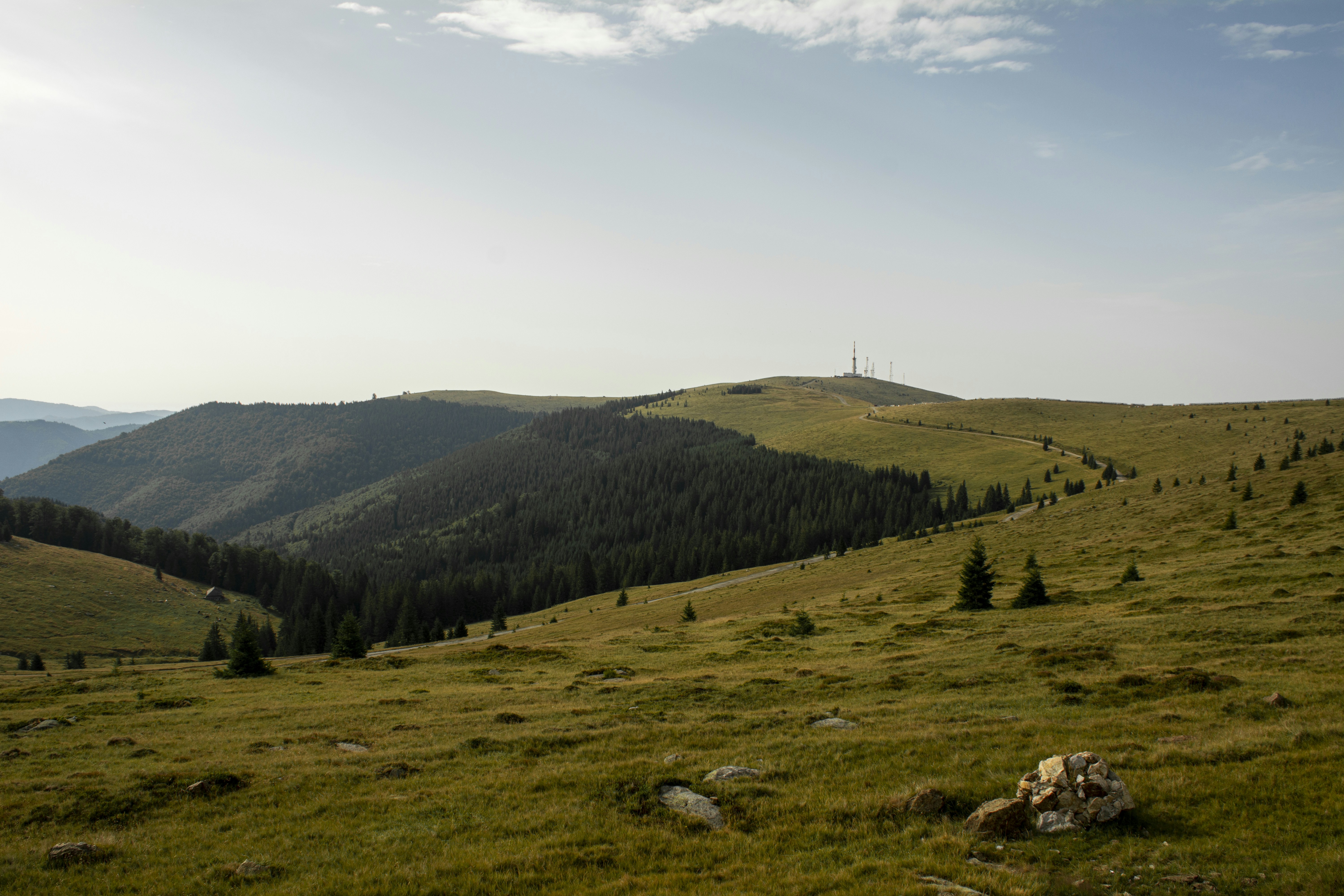 Green hills stretch toward a distant, blue sky.