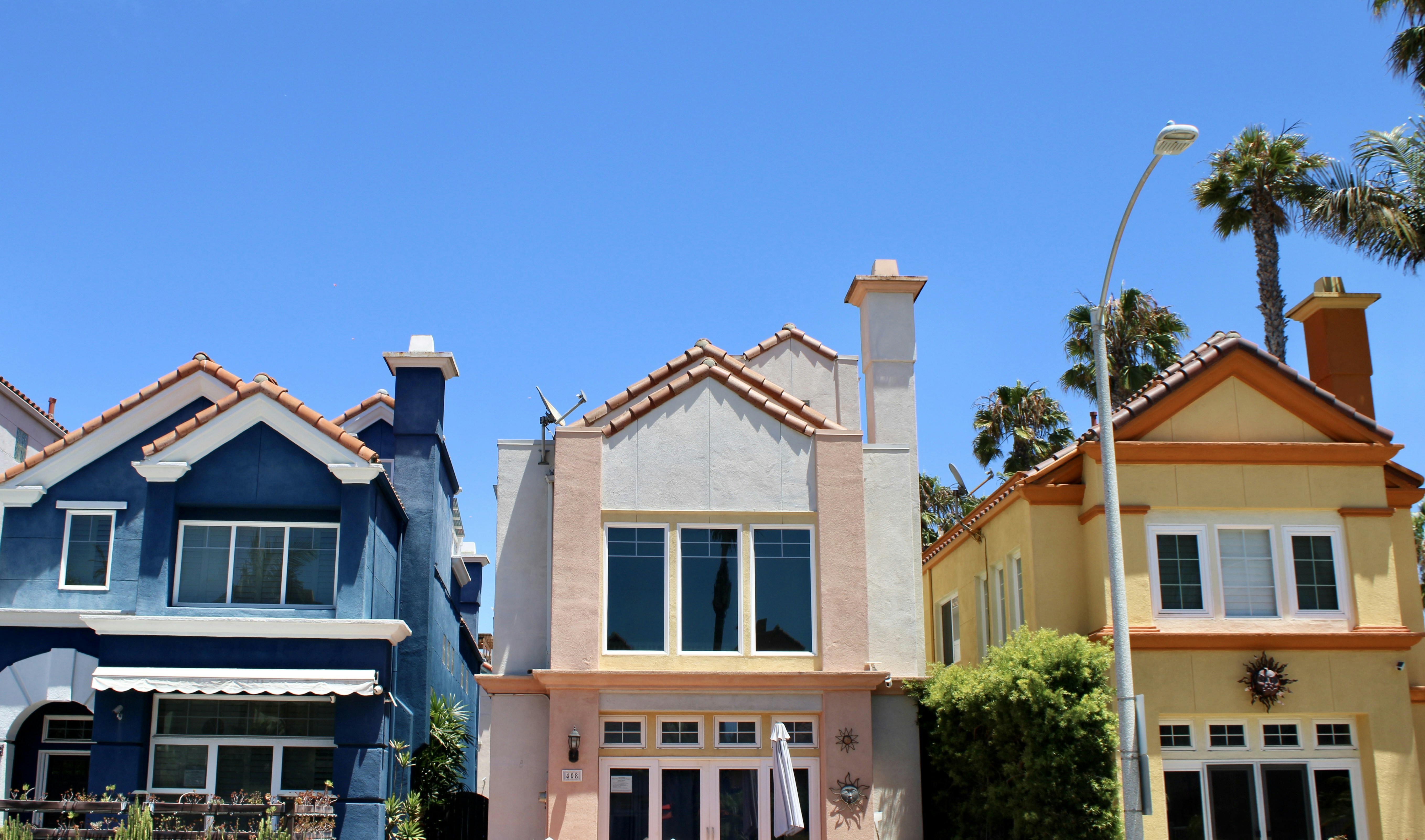 Colorful houses stand under a bright blue sky.