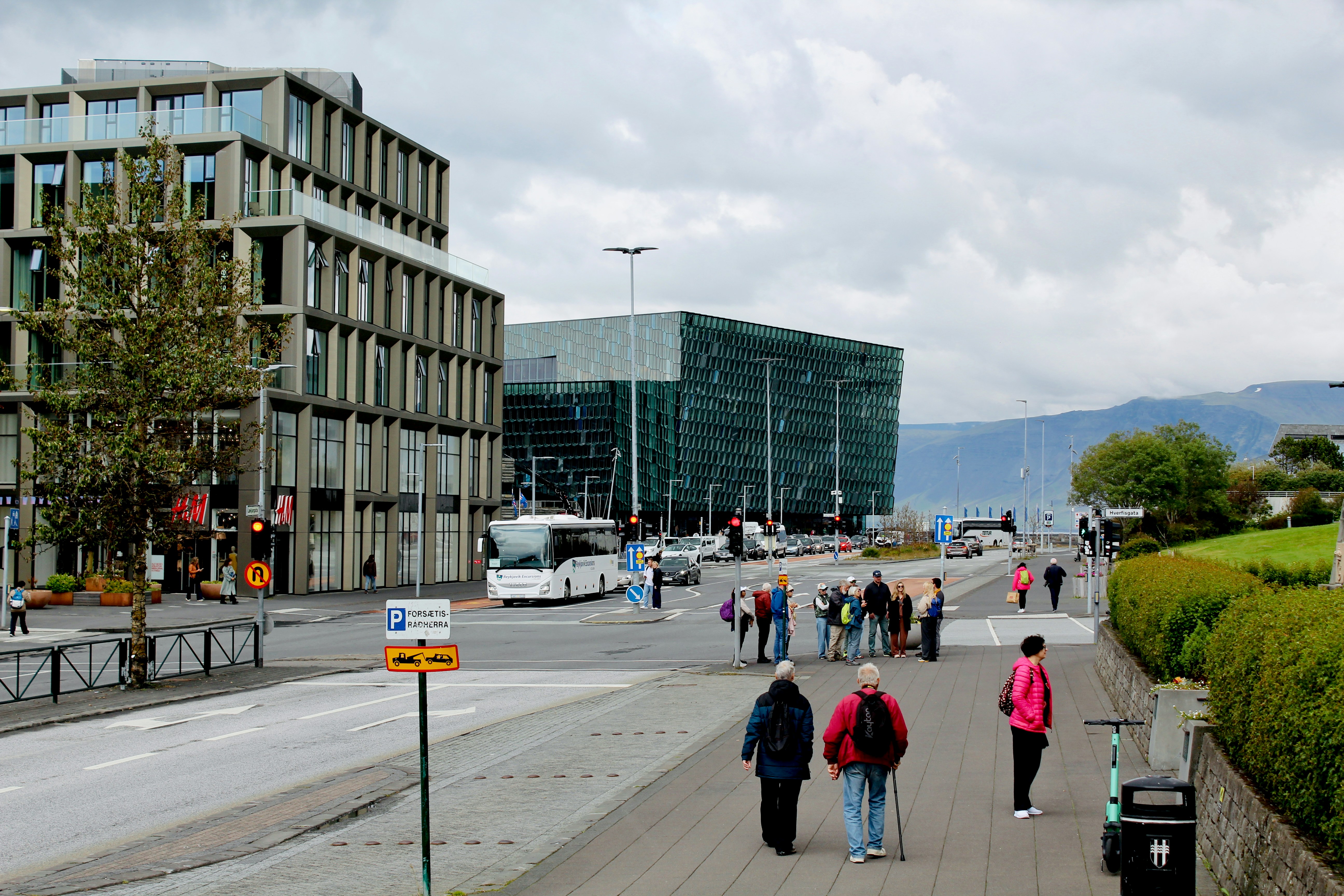 Modern buildings and people walk by the street.