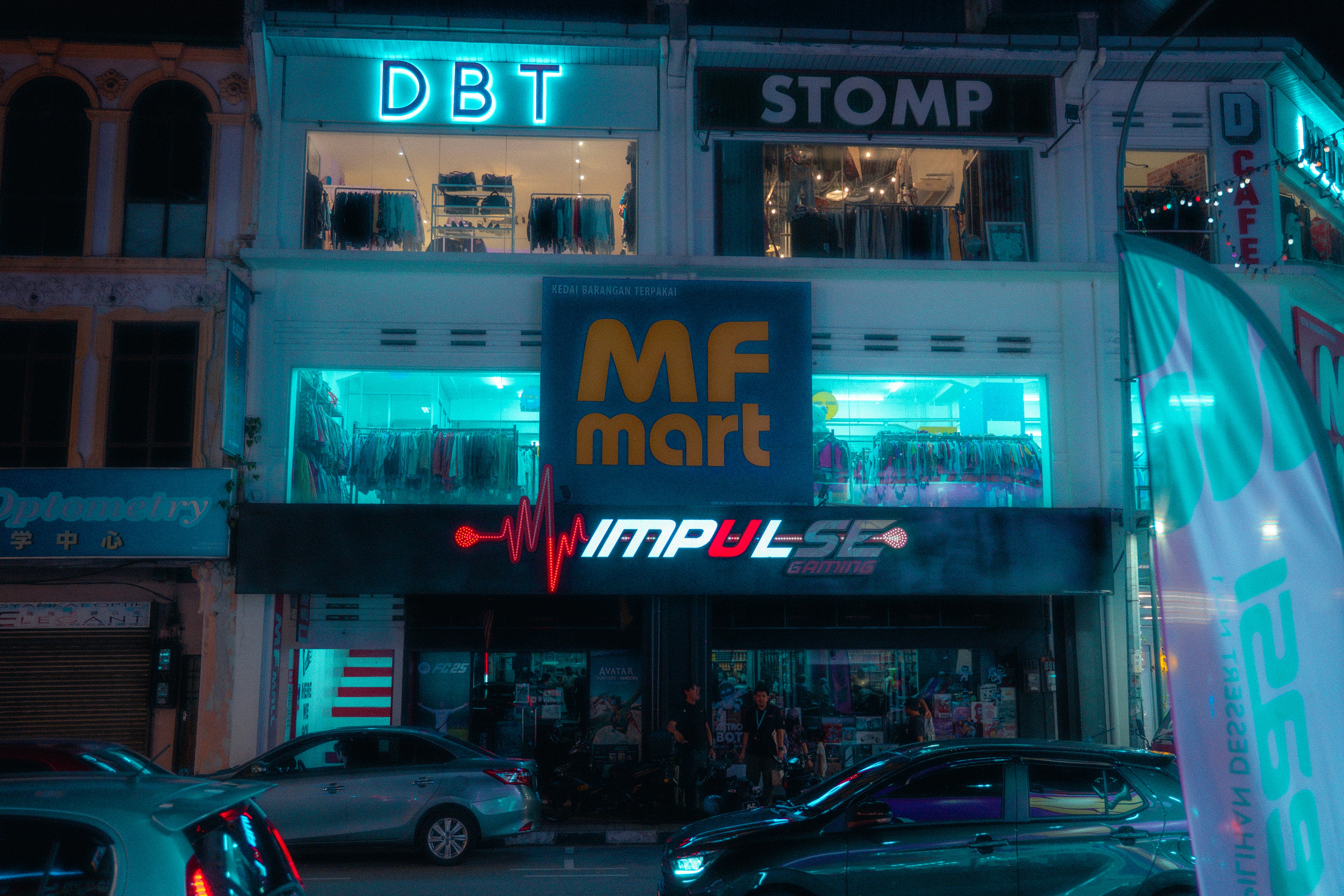 Neon signs illuminate a building at night.
