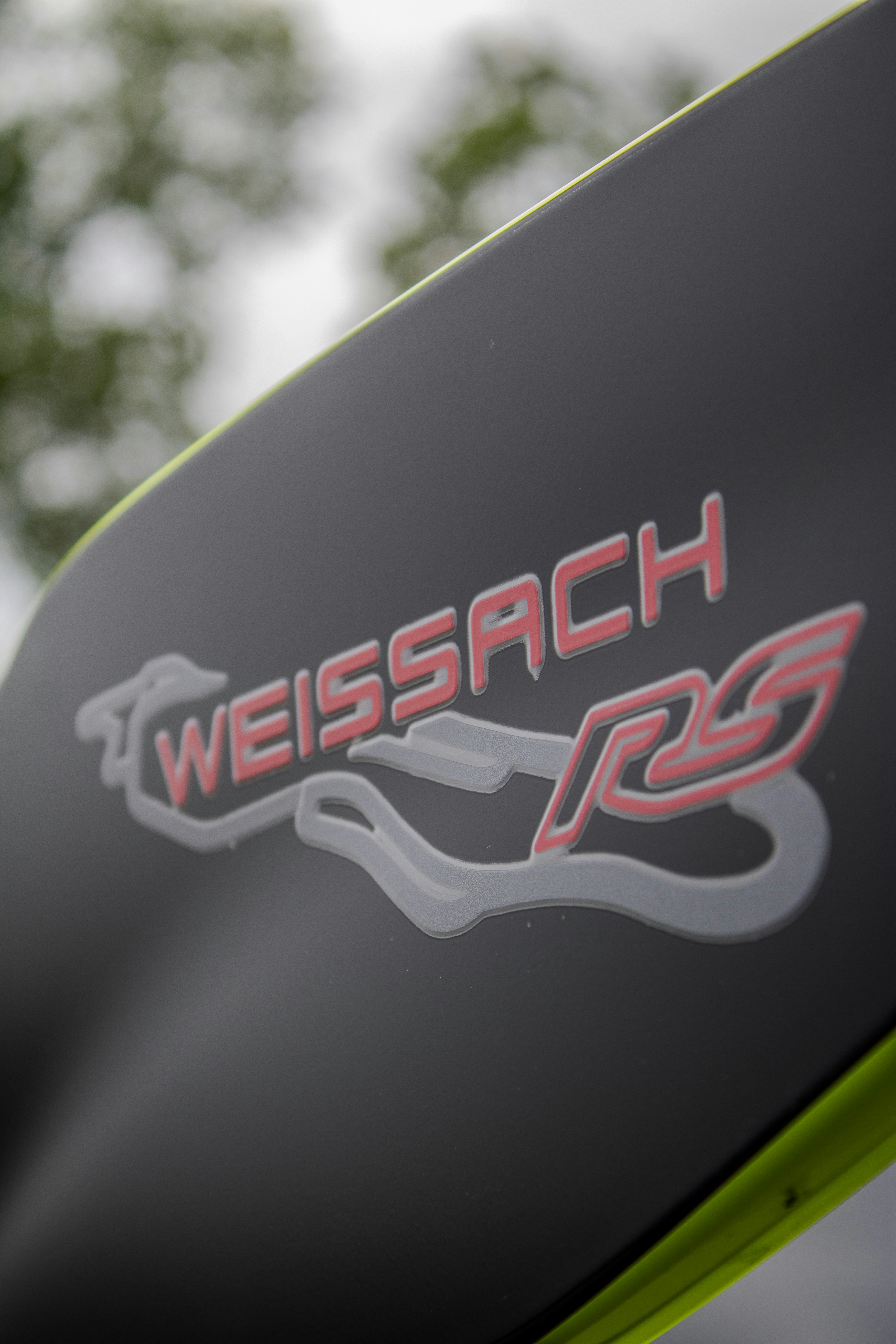 Das Bild zeigt ein "weissach rs"-Logo auf einem Auto.