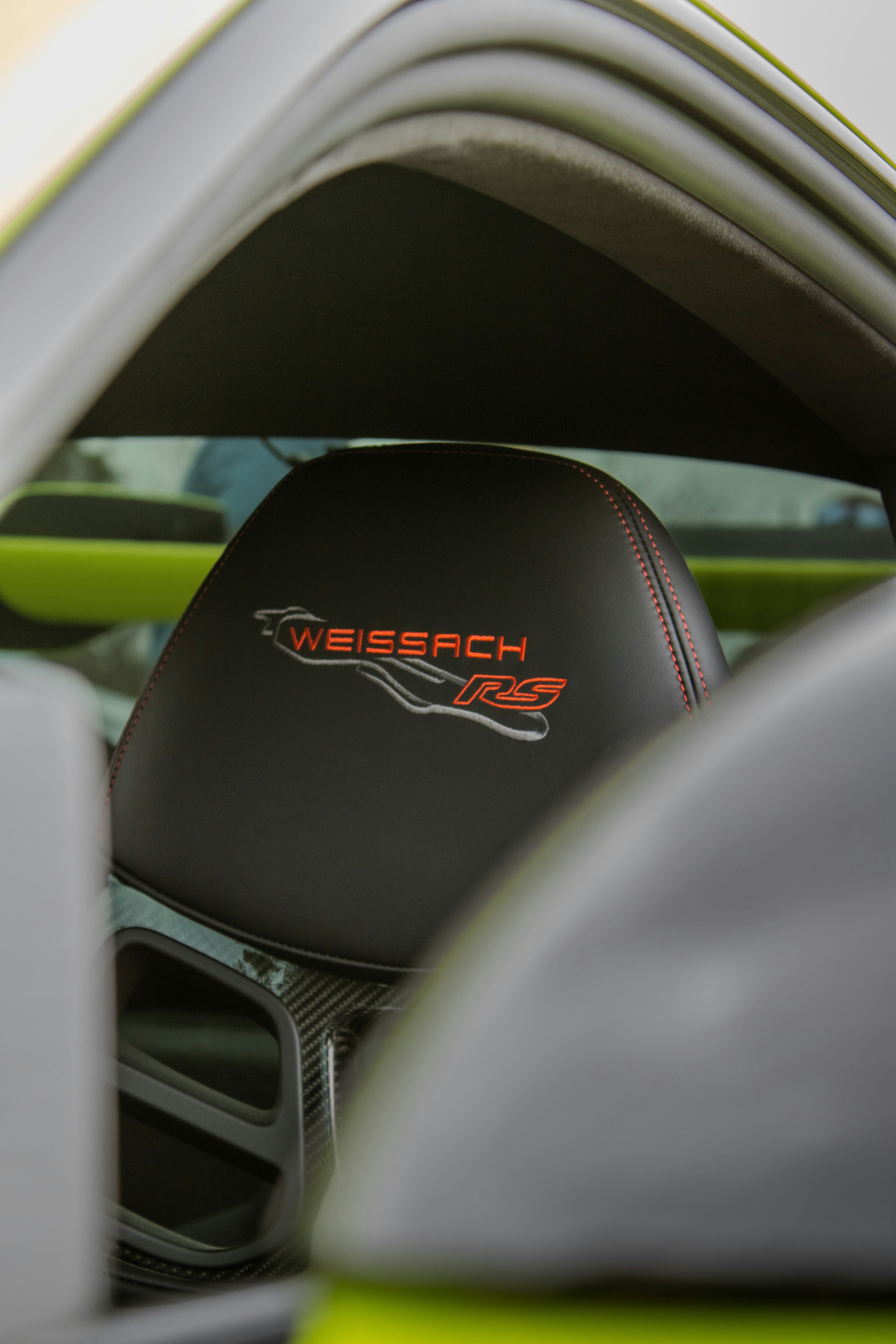 Ein schwarzer Kindersitz mit "weissach rs"-Logo.