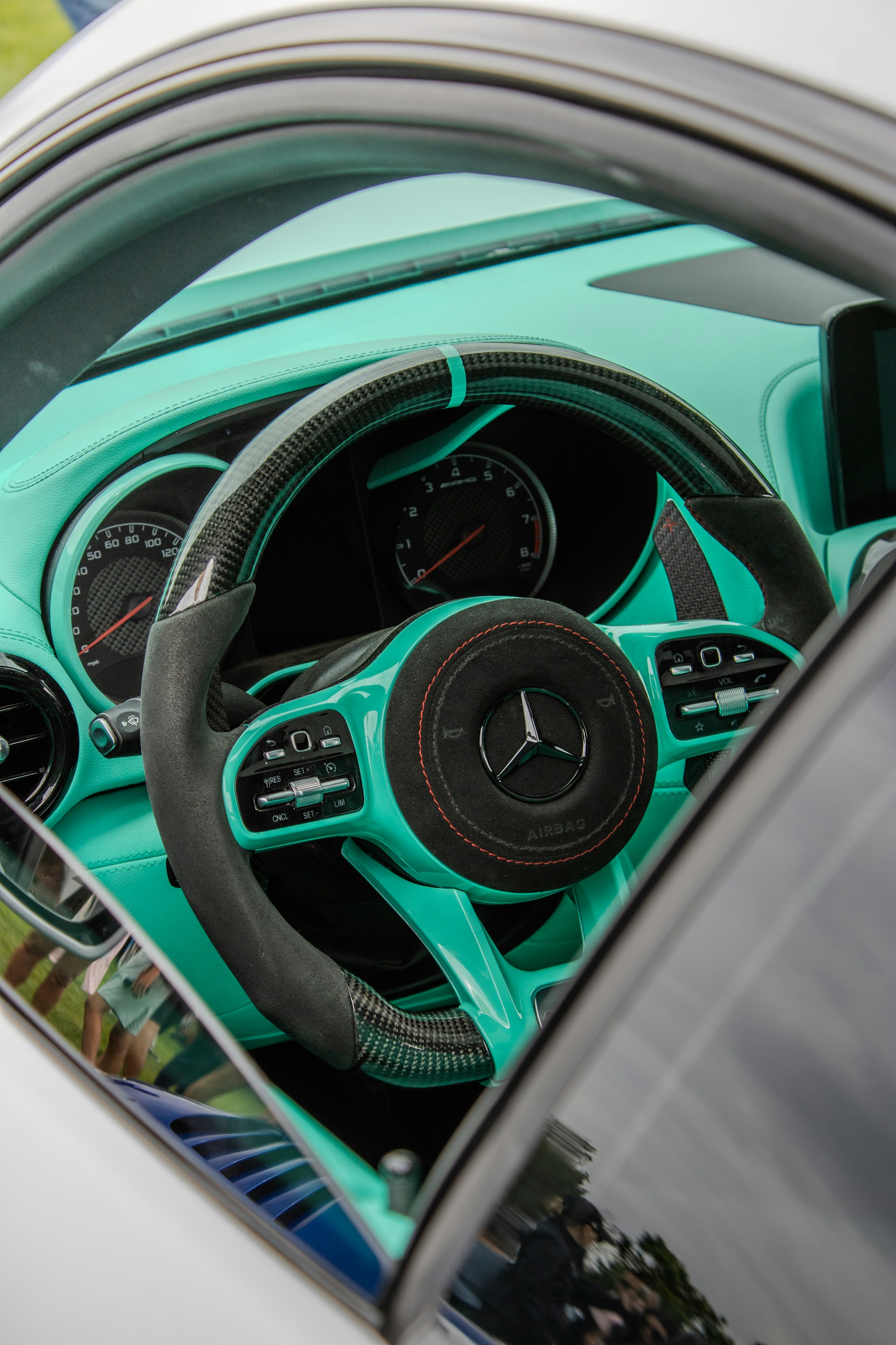 The interior of a teal mercedes car.