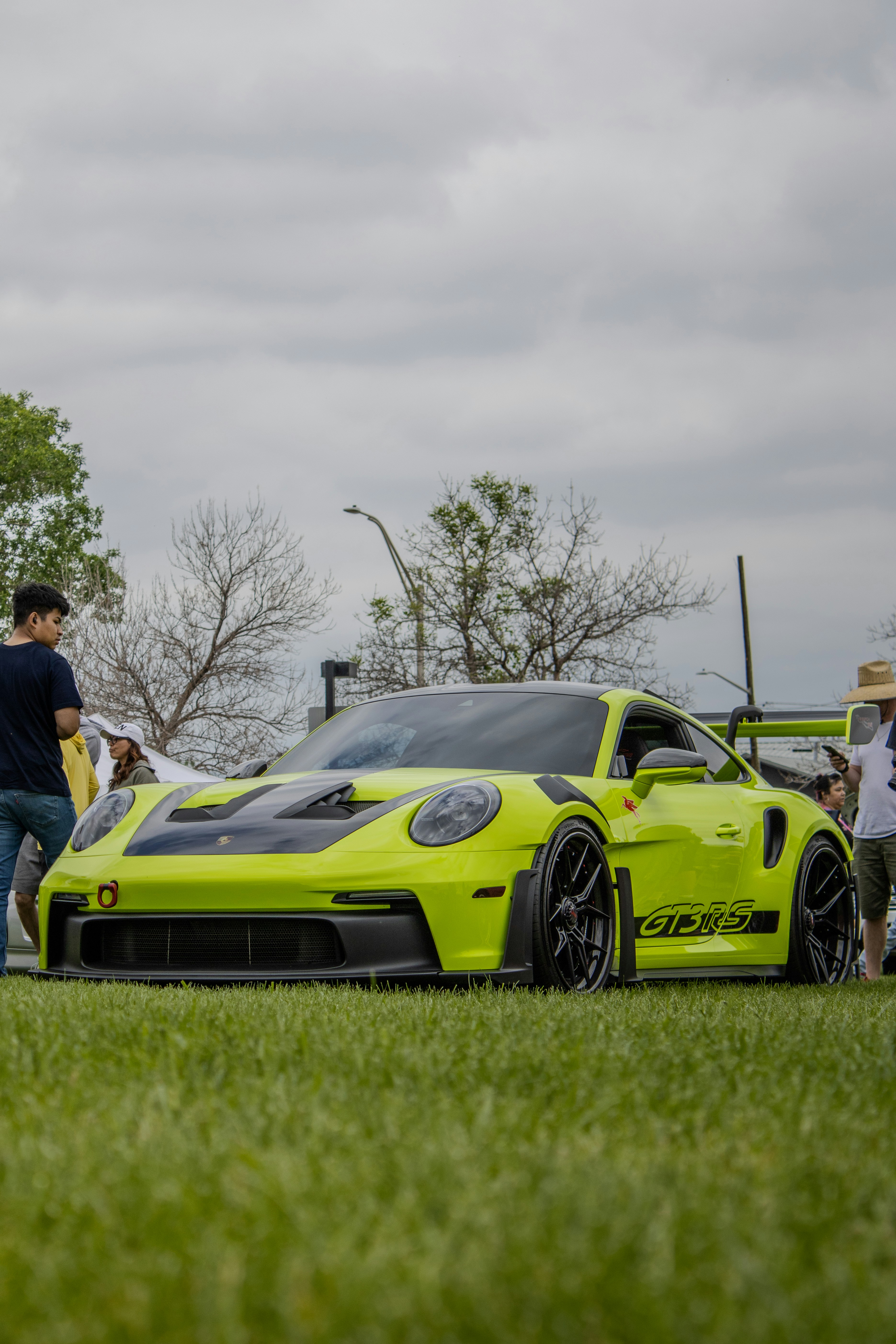 Draußen ist ein lindgrüner Porsche GT3 ausgestellt.