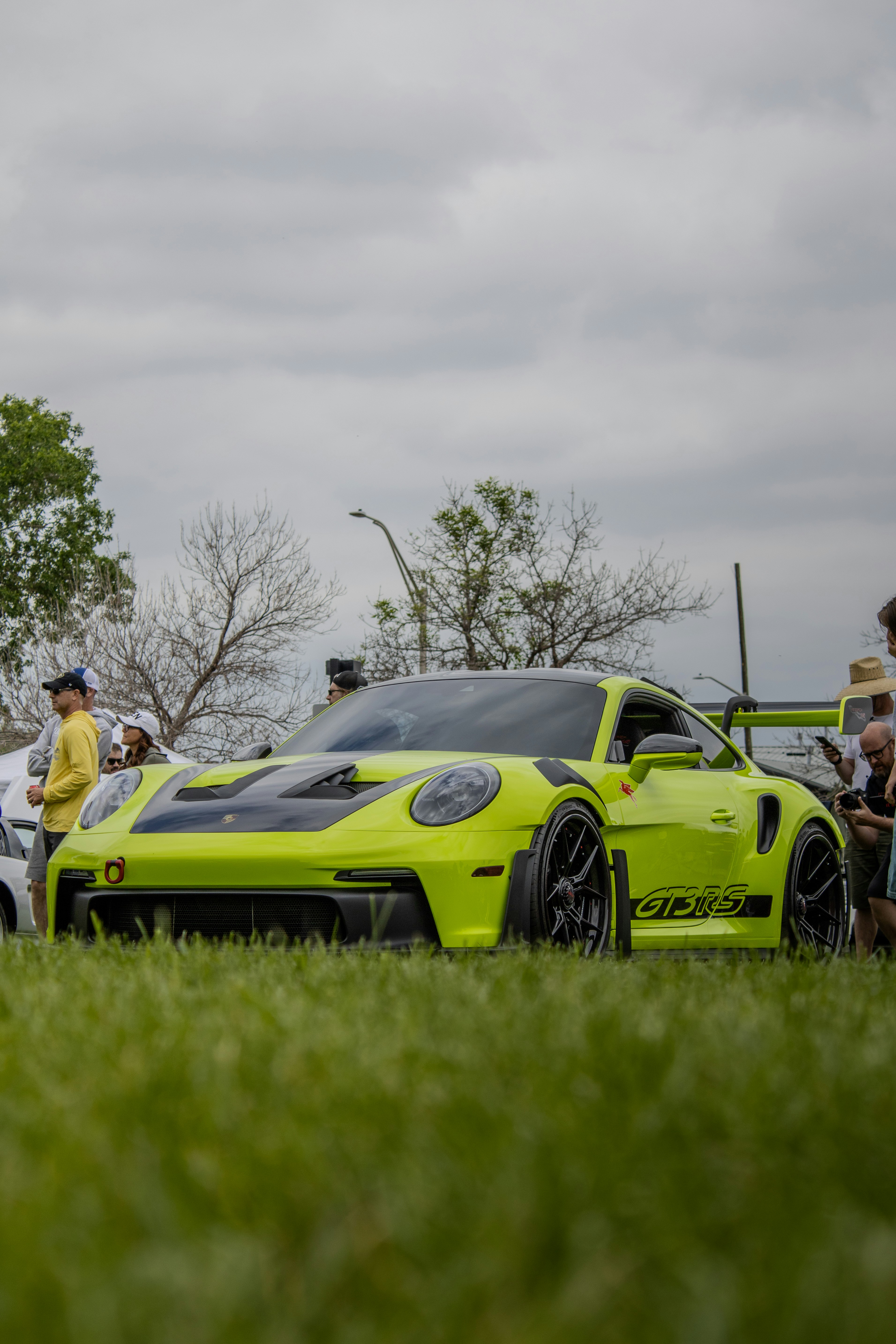 Ein knallgrüner Porsche 911 gt3r steht auf Gras.