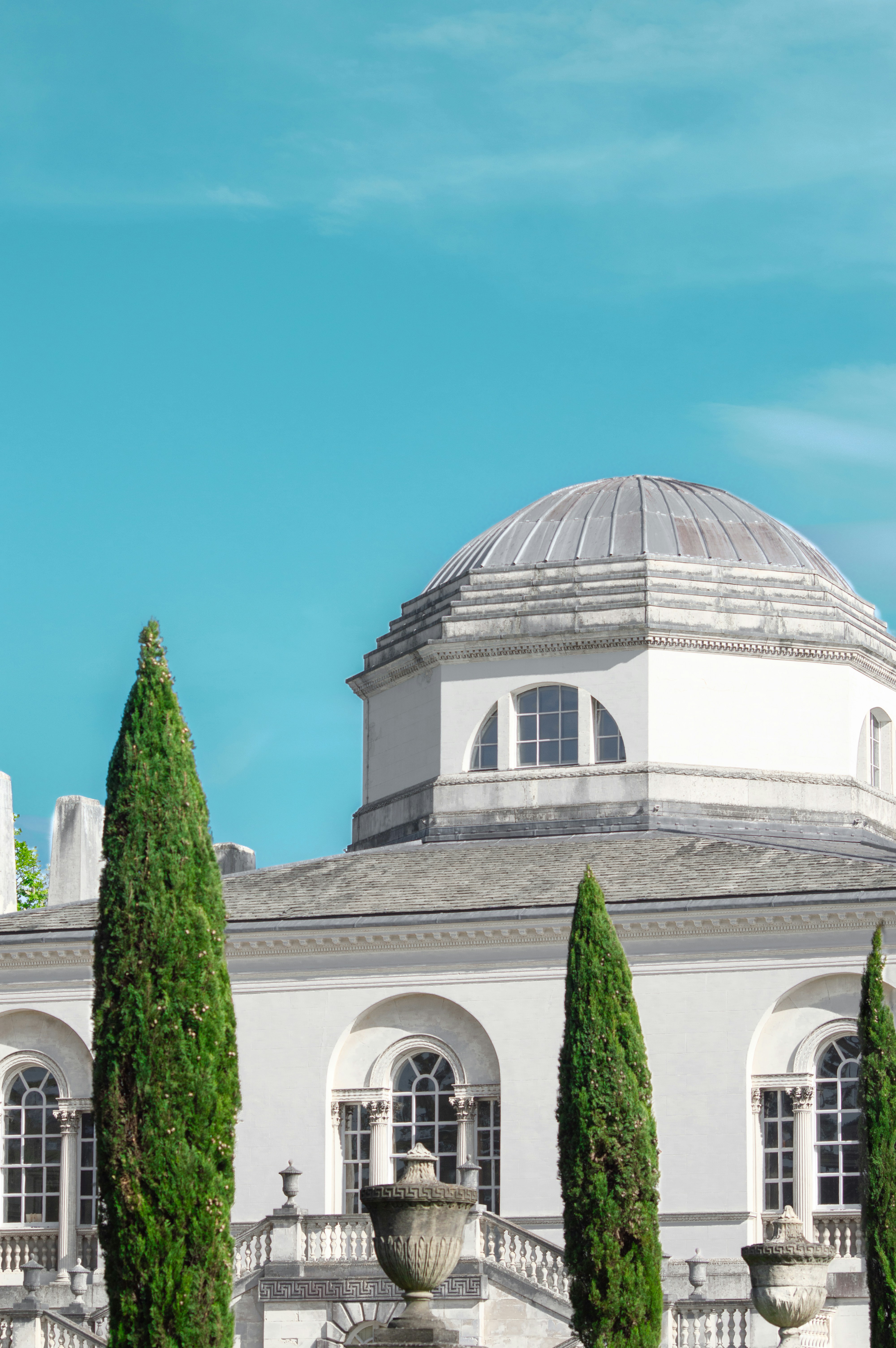 Elegant building with dome stands under a blue sky.