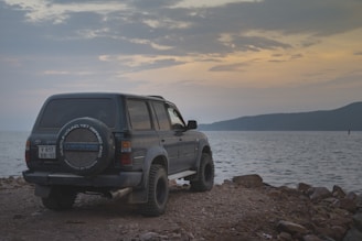 A black suv parked by the water.