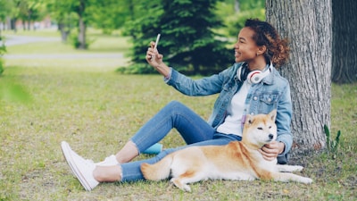 Woman taking a selfie with her dog in the park.