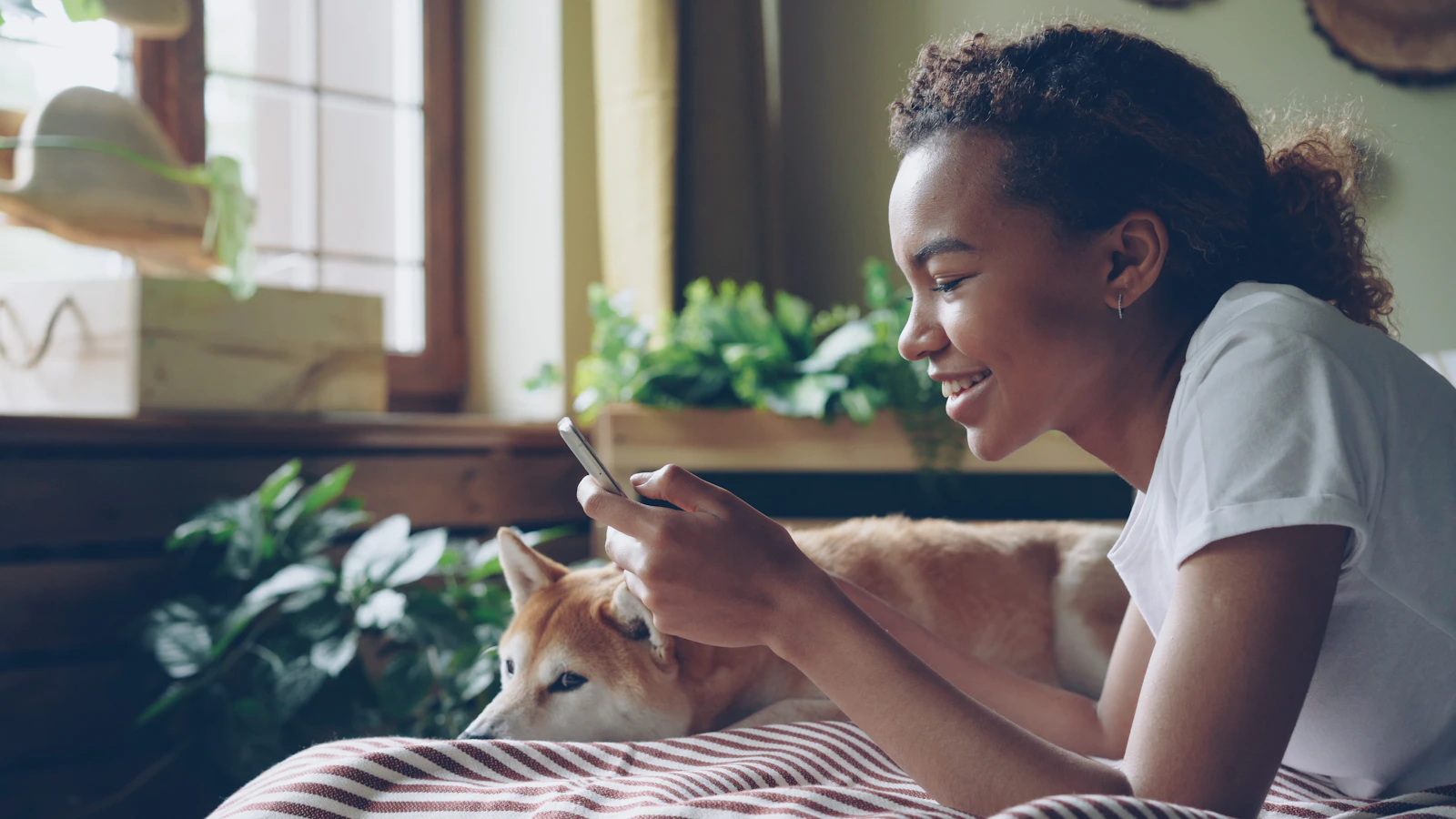 Real pet owner using a smartphone beside a dog at home