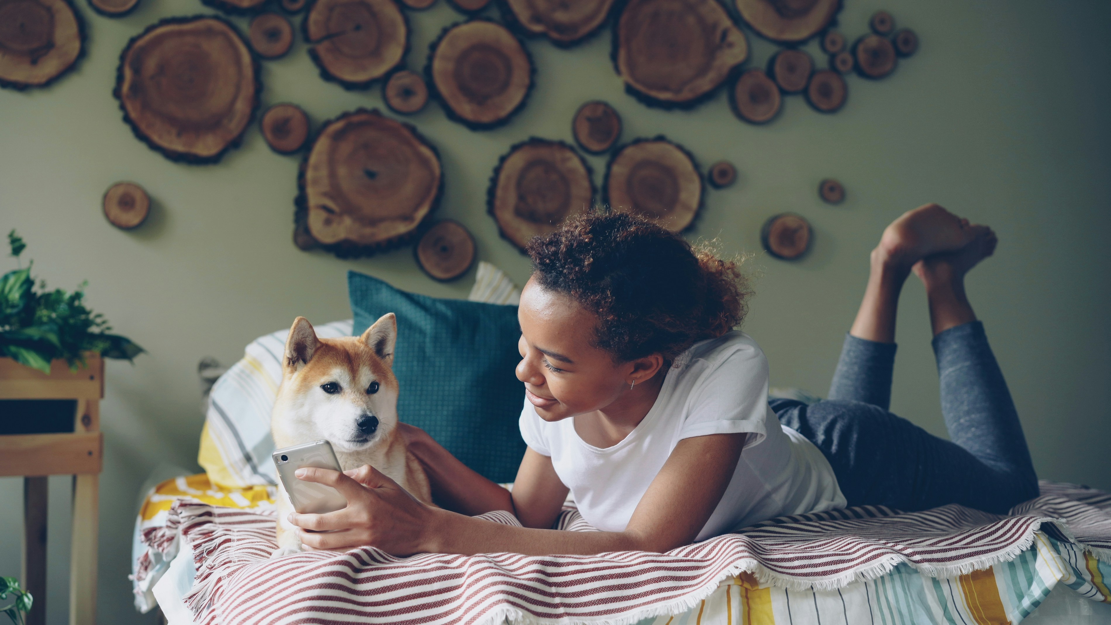 Woman and dog look at a phone together.