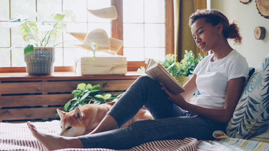 Woman reading a book with her dog nearby