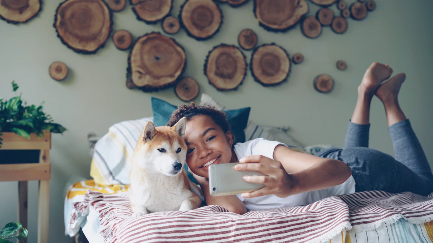 Real pet owner using a smartphone with a dog at home
