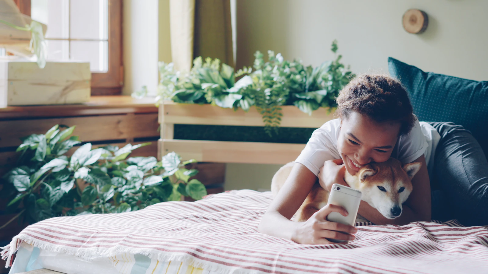 Tutora relaxando em casa com o cachorro e usando o celular