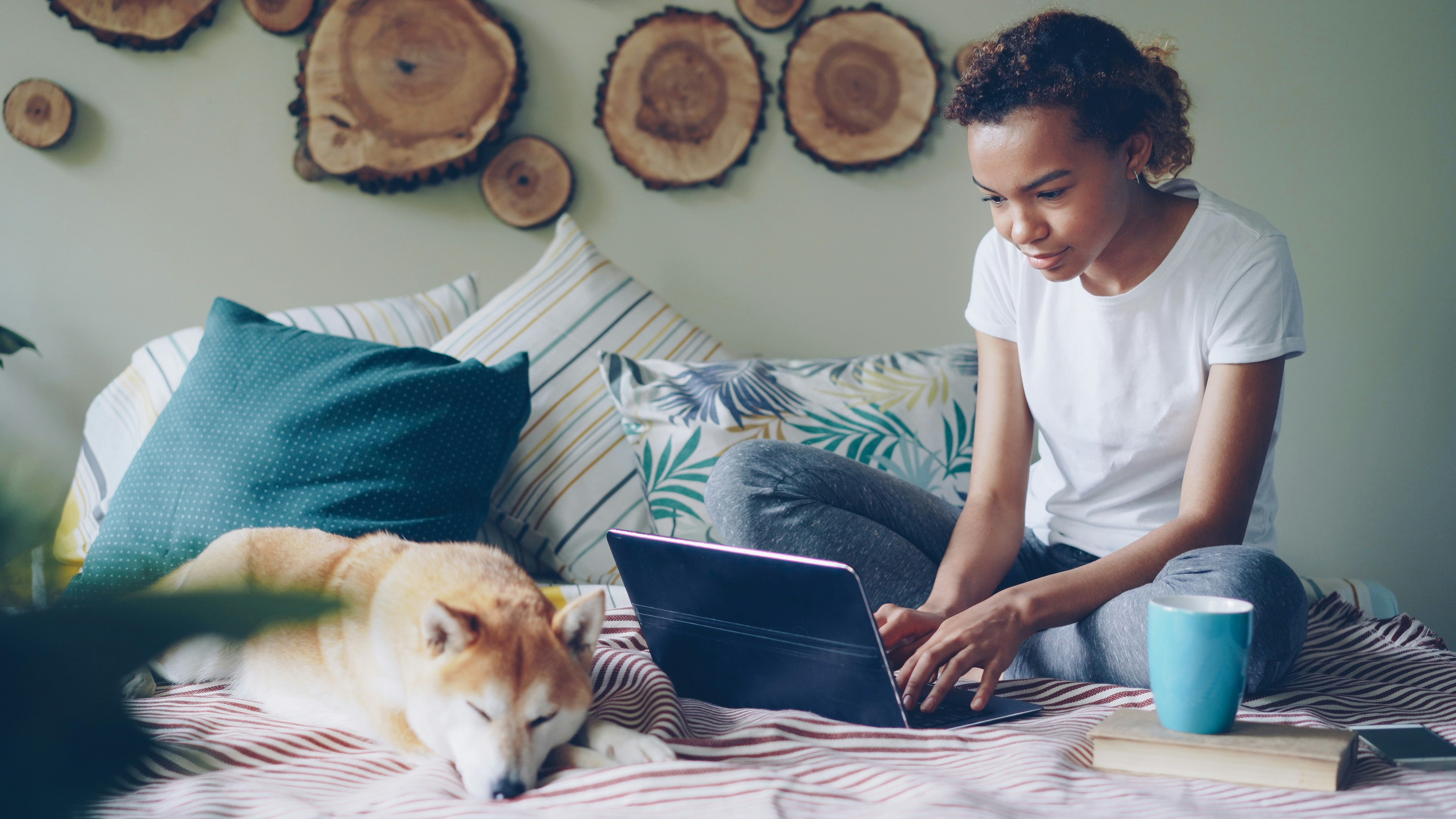 Woman works on a laptop with her dog.