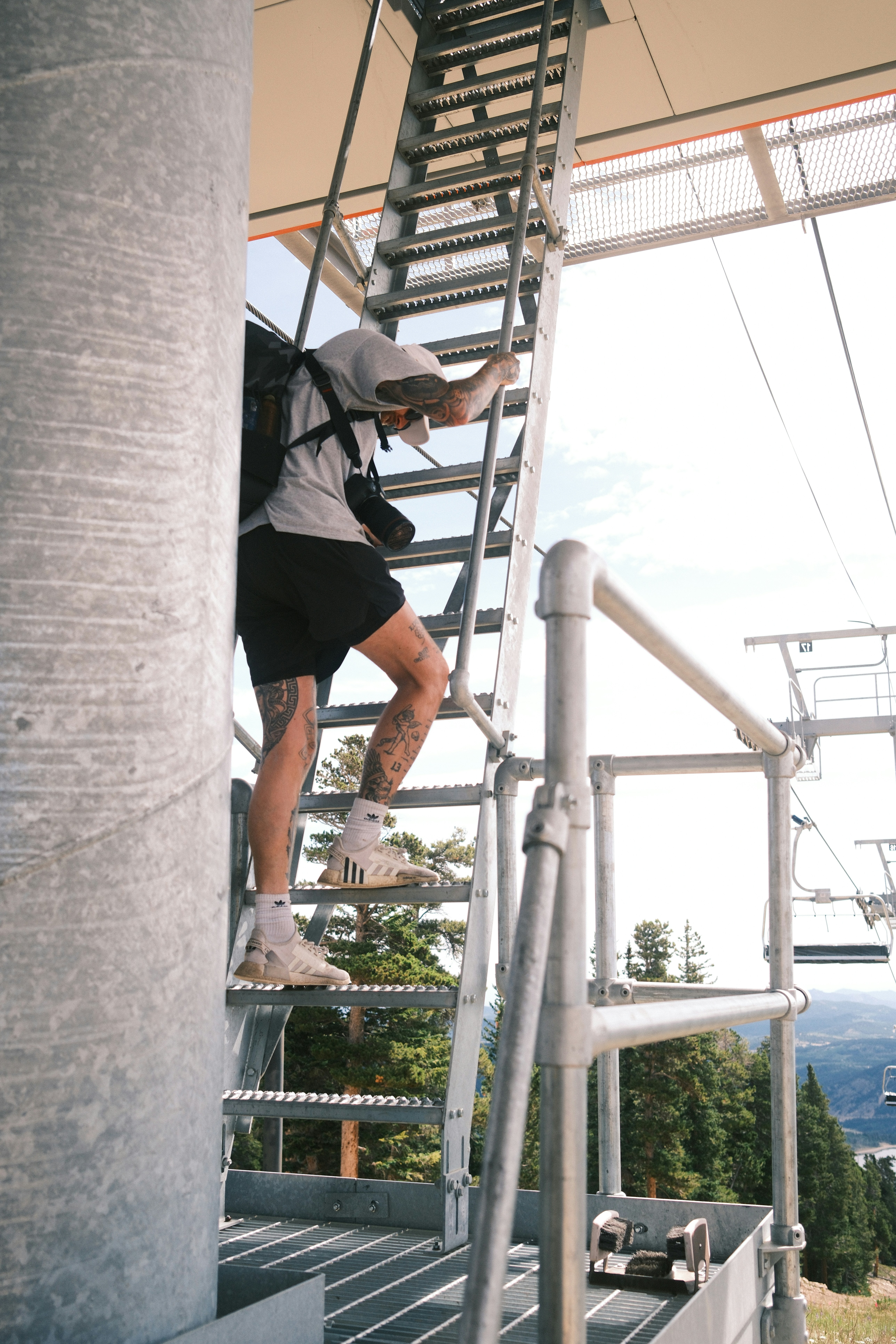 A person climbs a metal ladder outdoors.