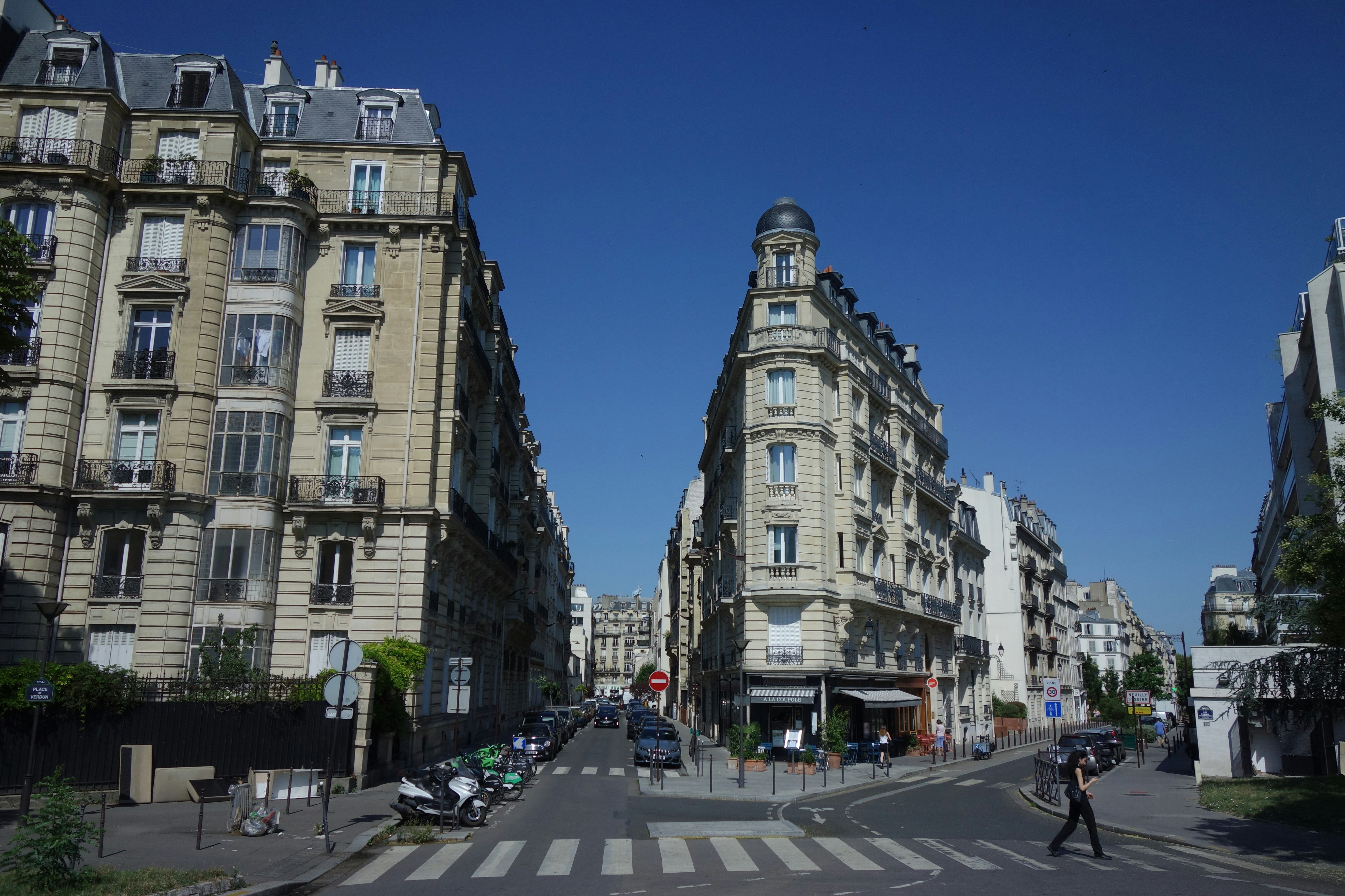 Buildings line a sunny street in paris.