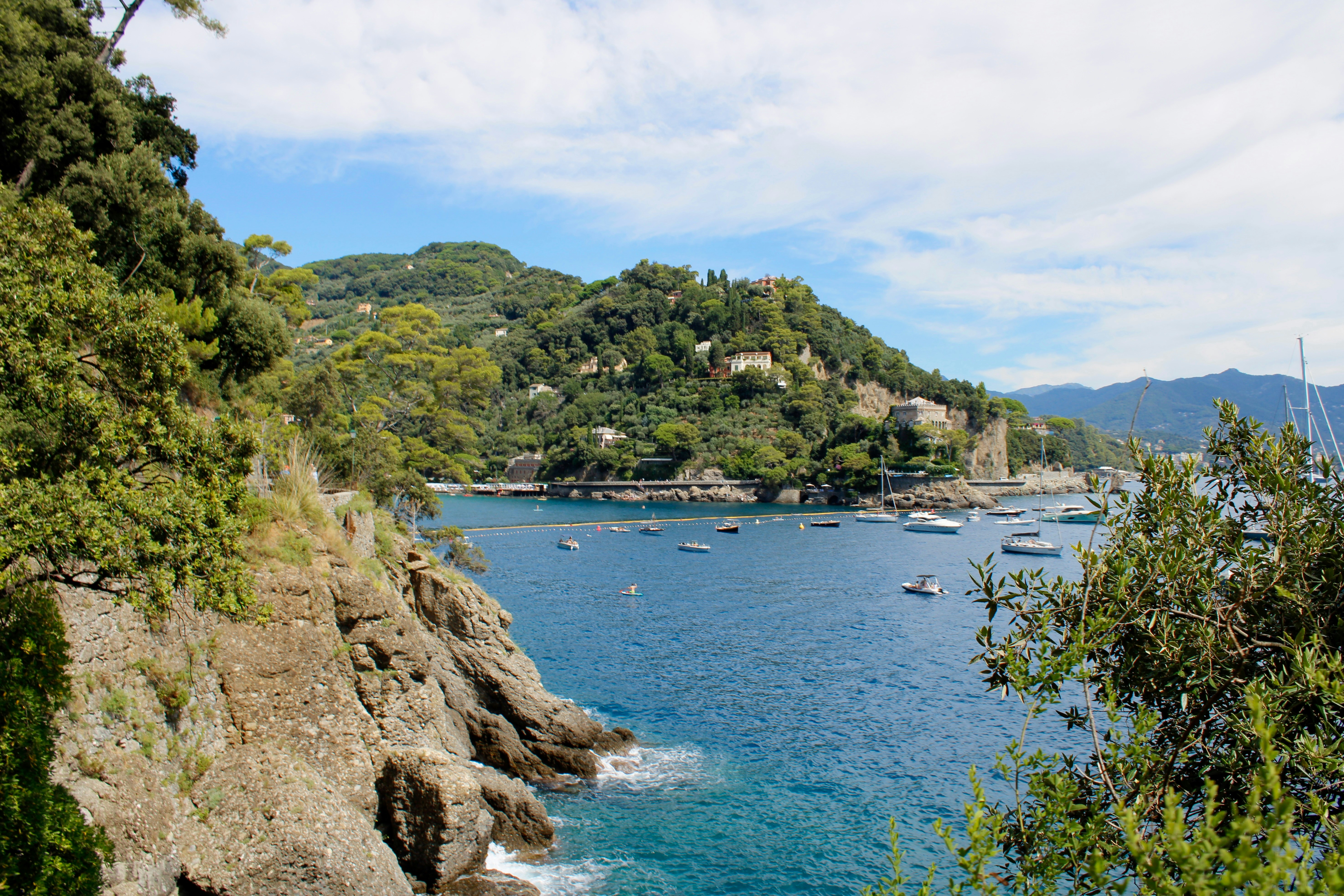 Coastal view with mountains and boats on the water.