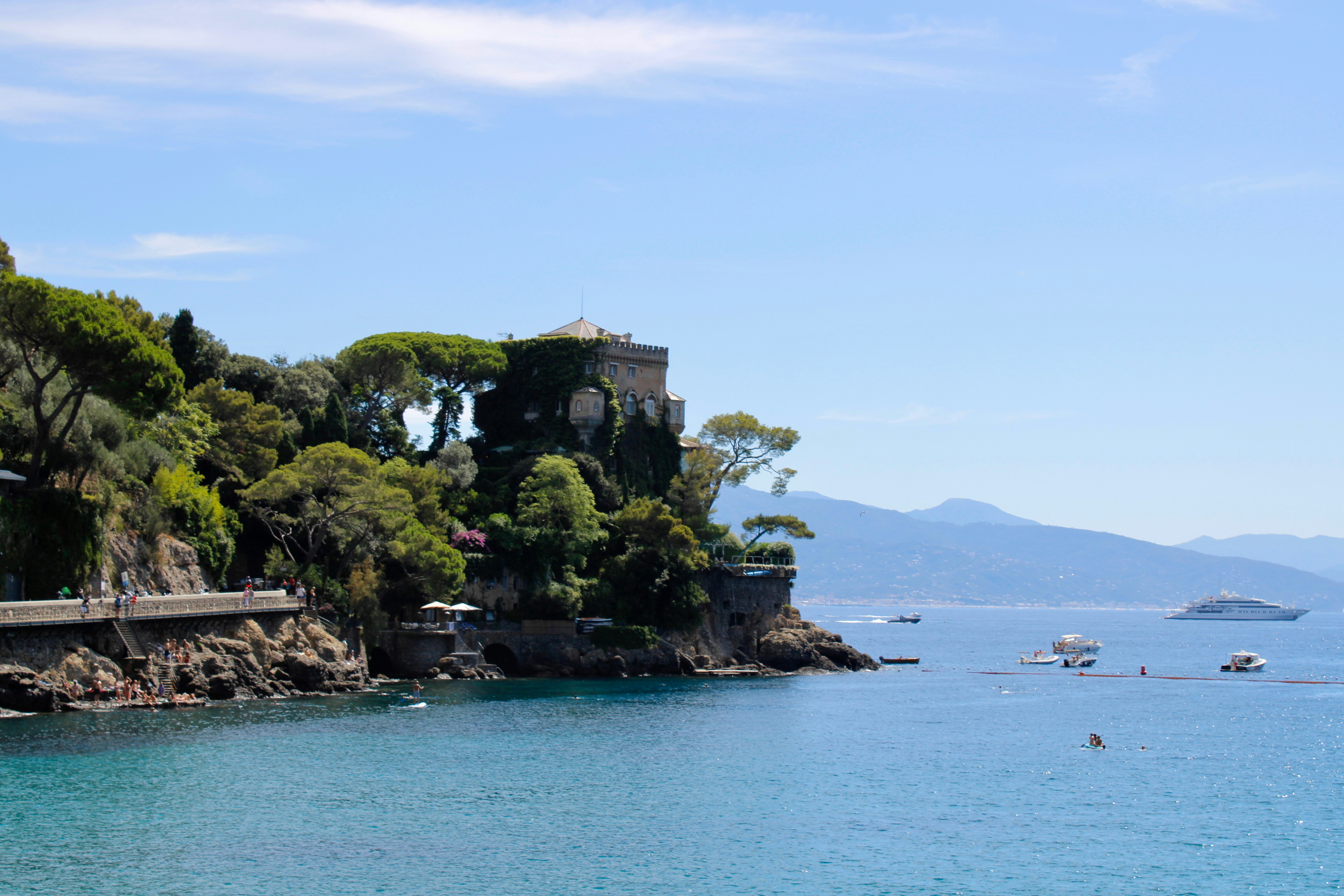 Coastal scenery with trees and a castle.