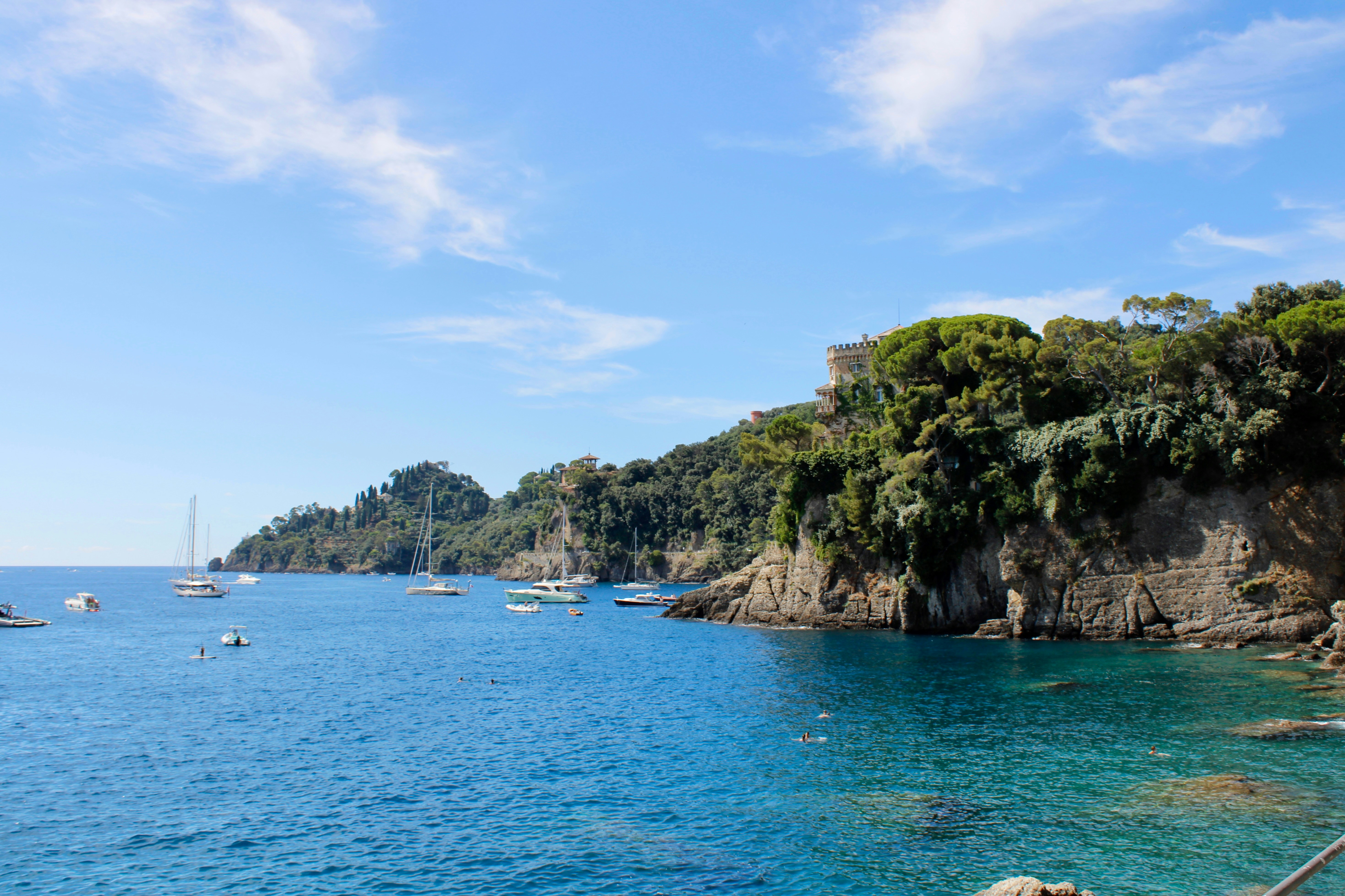 Boats dot a vibrant bay on a sunny day.