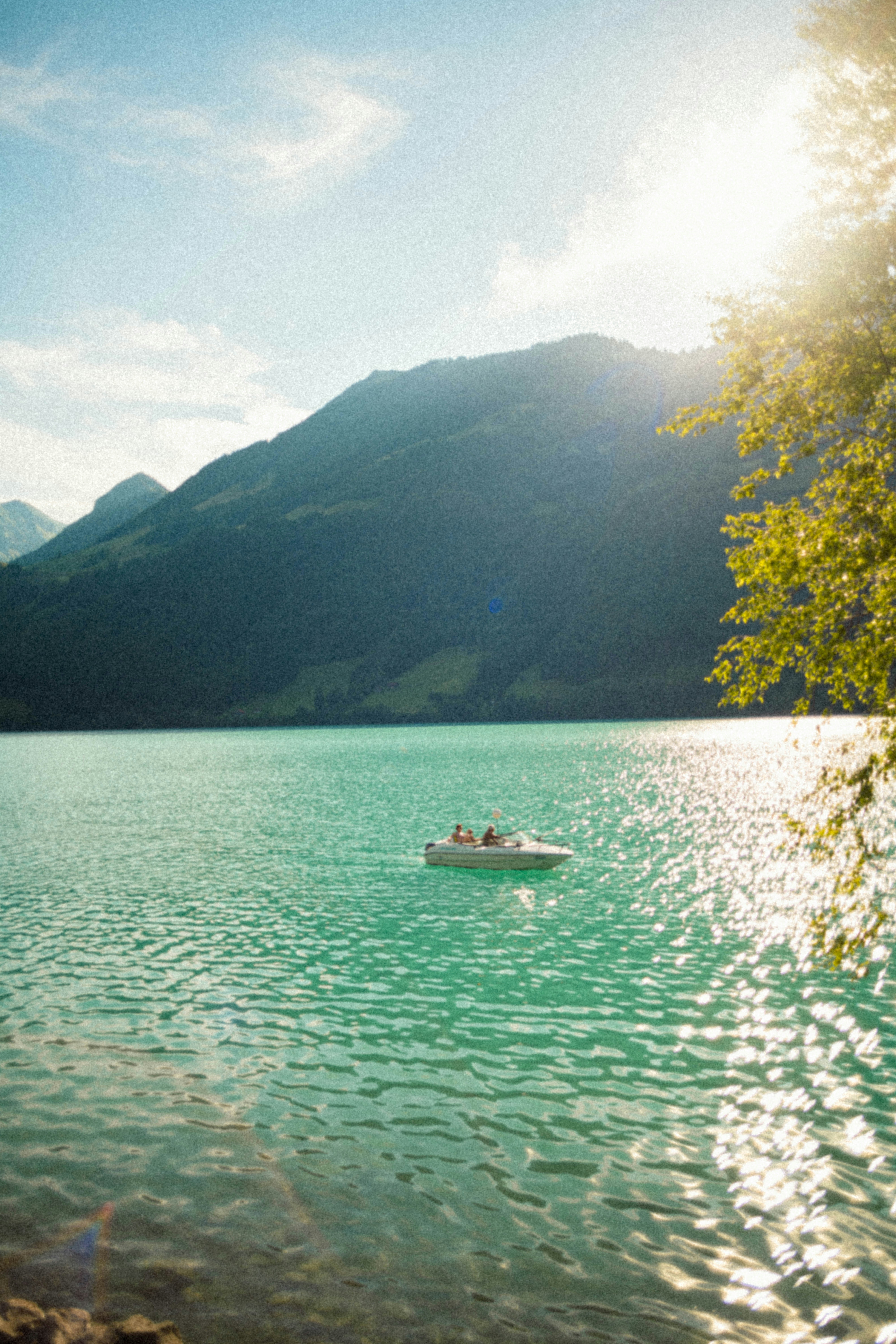산 근처의 청록색 호수에 떠 있는 보트.