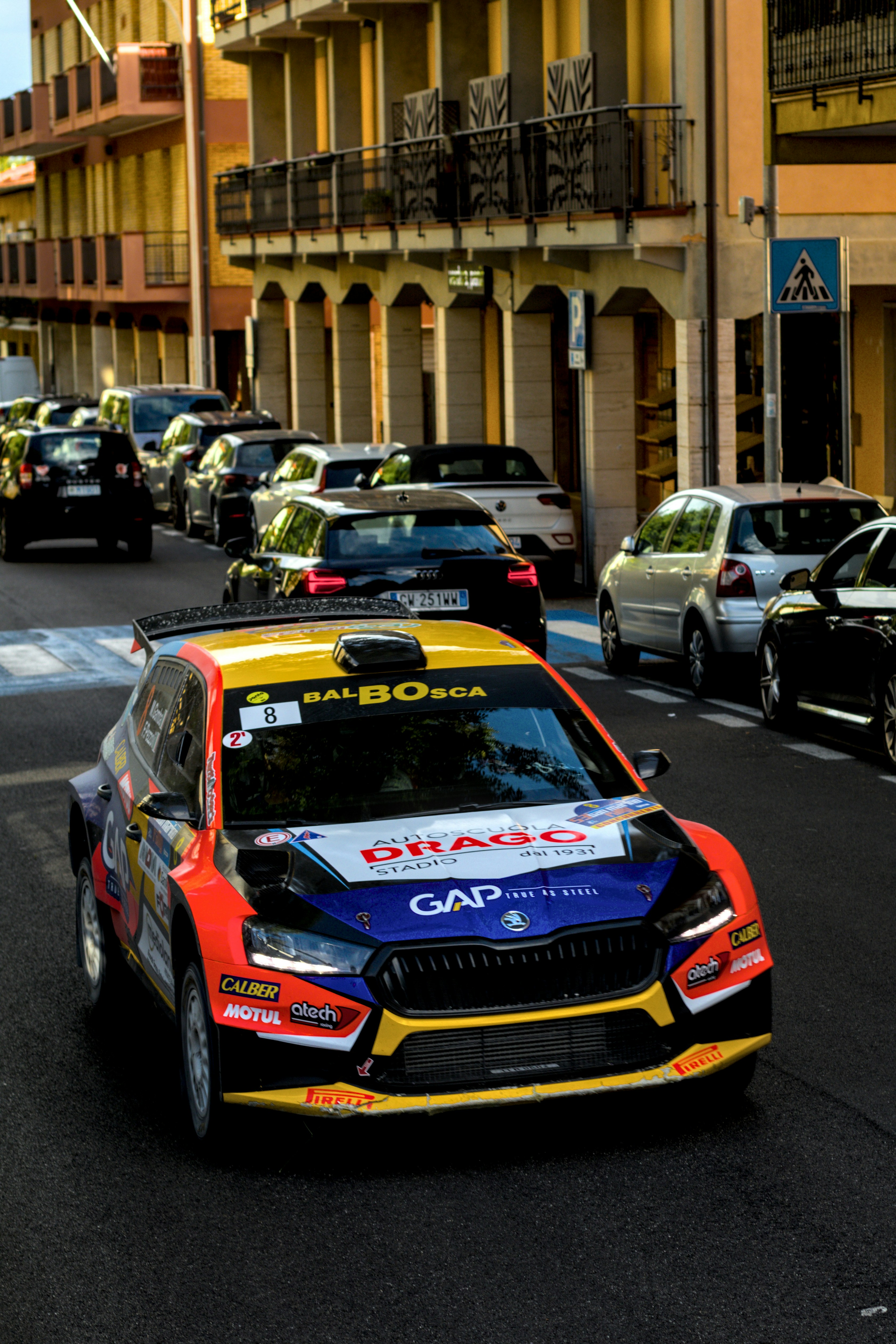 A rally car is driving down a city street.