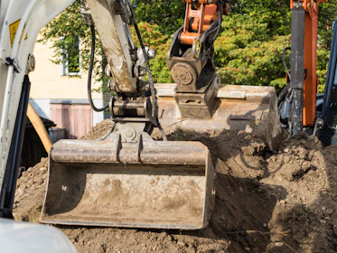 Excavator scoops up dirt in a construction zone.