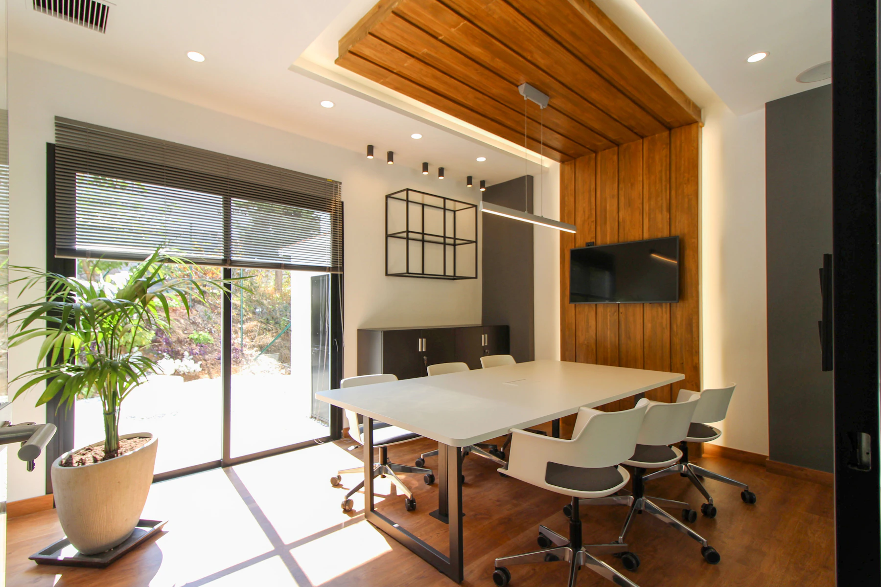 A bright modern meeting room with a wooden ceiling and natural light