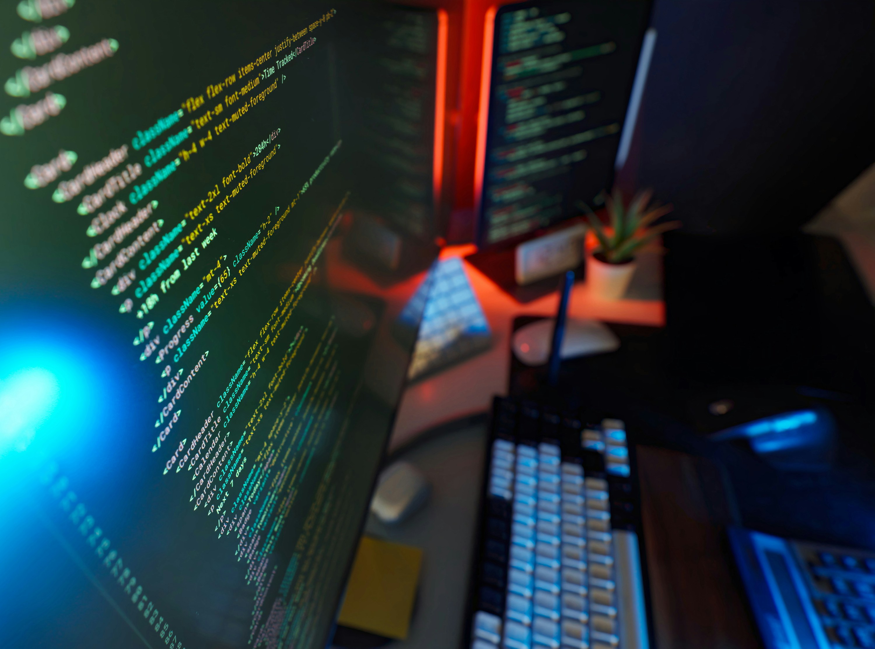 Cyber coding remote workstation digital studio with colorful color lights, code on screen and modern peripherals. Concept of futuristic remote job, IT support, tech knowledge and software development