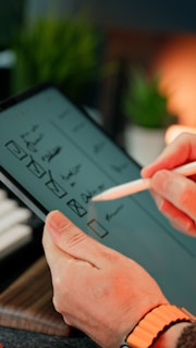 A person is sketching on a tablet.