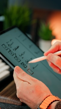 A person is sketching on a tablet.