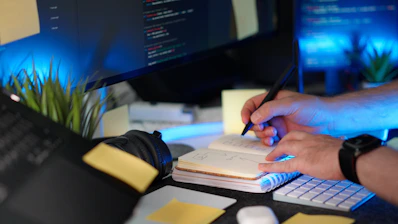 A person codes while taking notes.