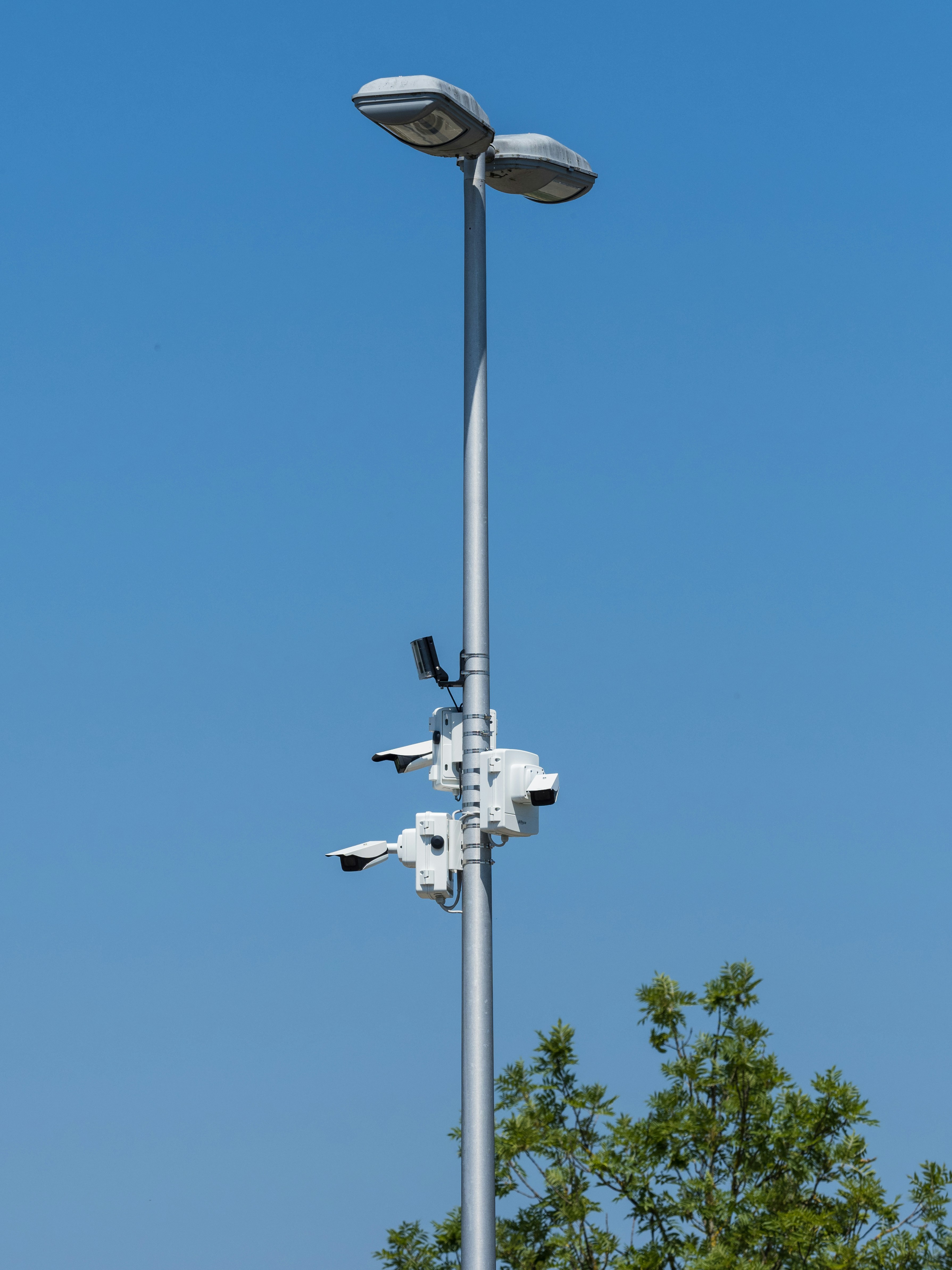 Security cameras are mounted on a tall pole.