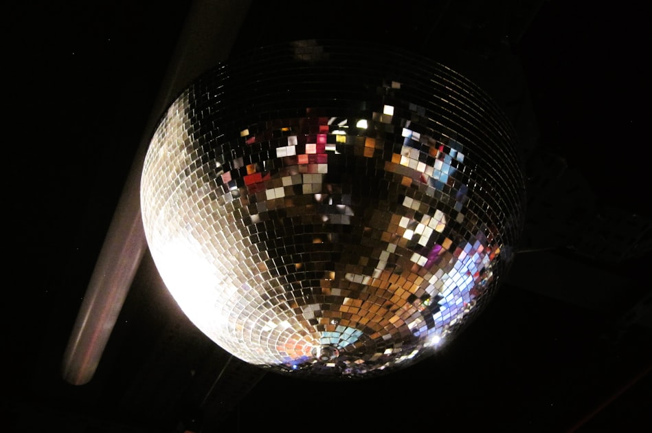 Bright disco ball reflecting colorful lights against a dark background