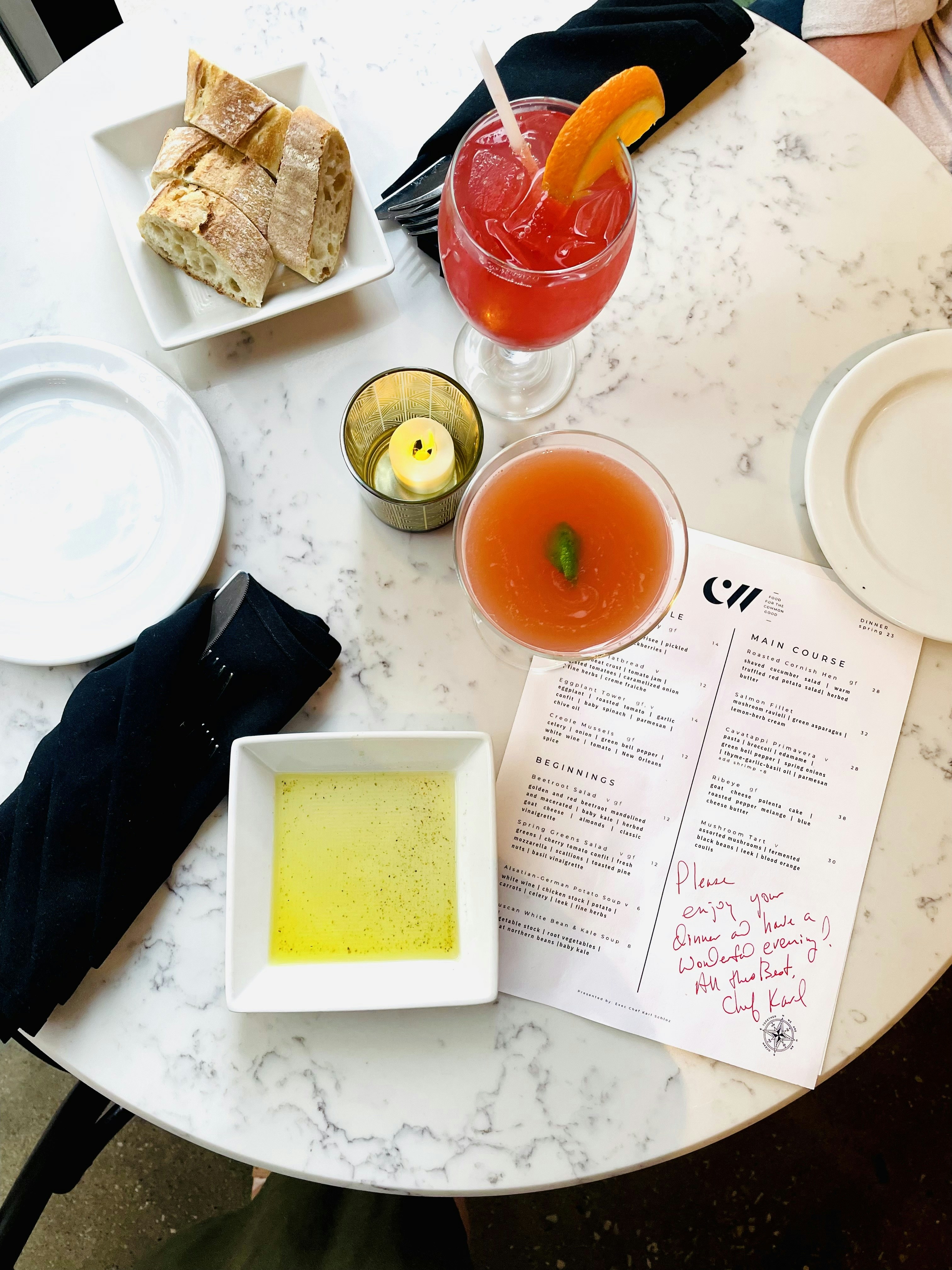 Cocktails, bread, and menu items displayed on a table.