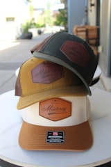 Three hats with "monterey" logos are stacked.