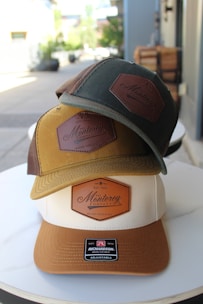 Three hats with "monterey" logos are stacked.