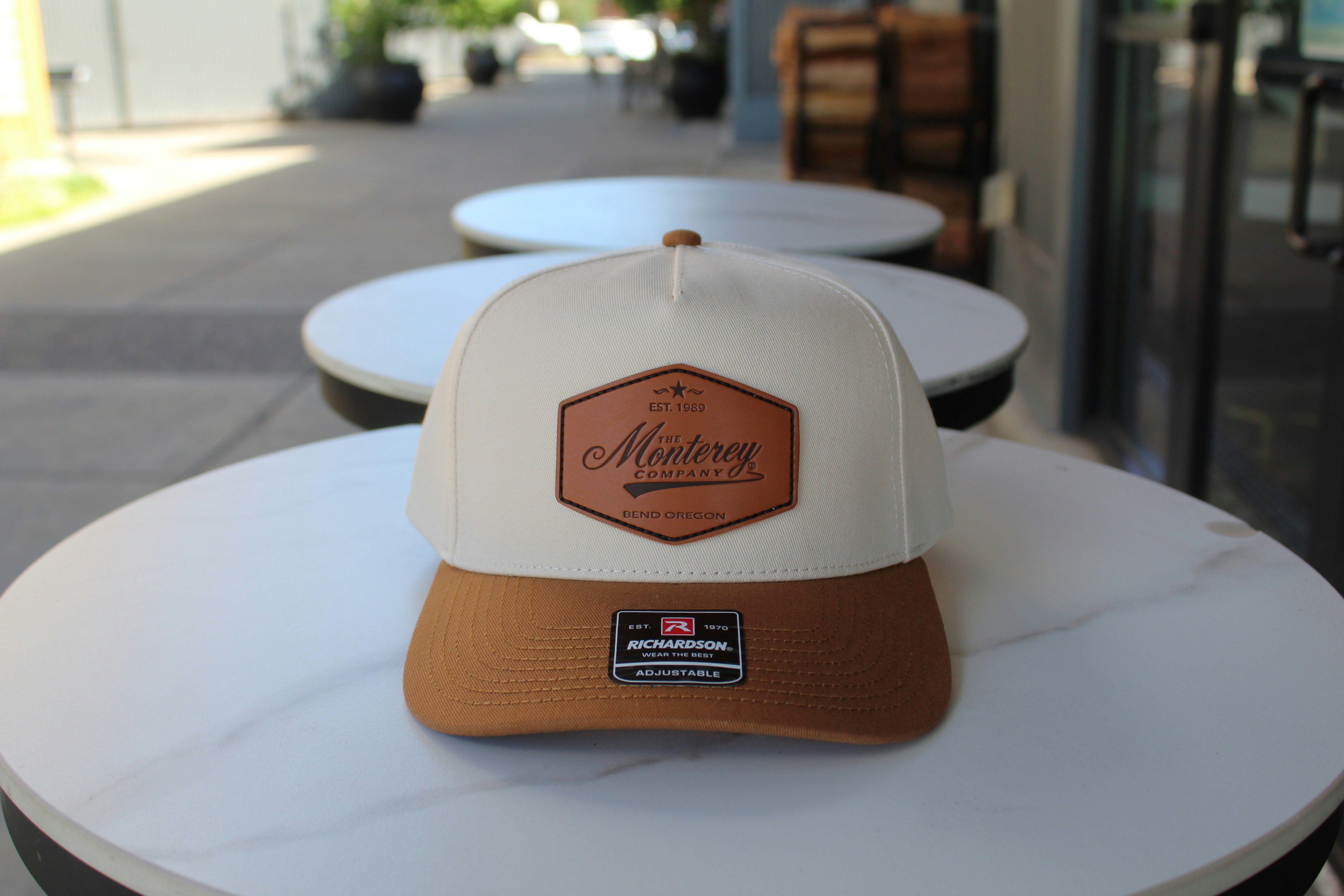 A hat with a leather patch sits on a table.