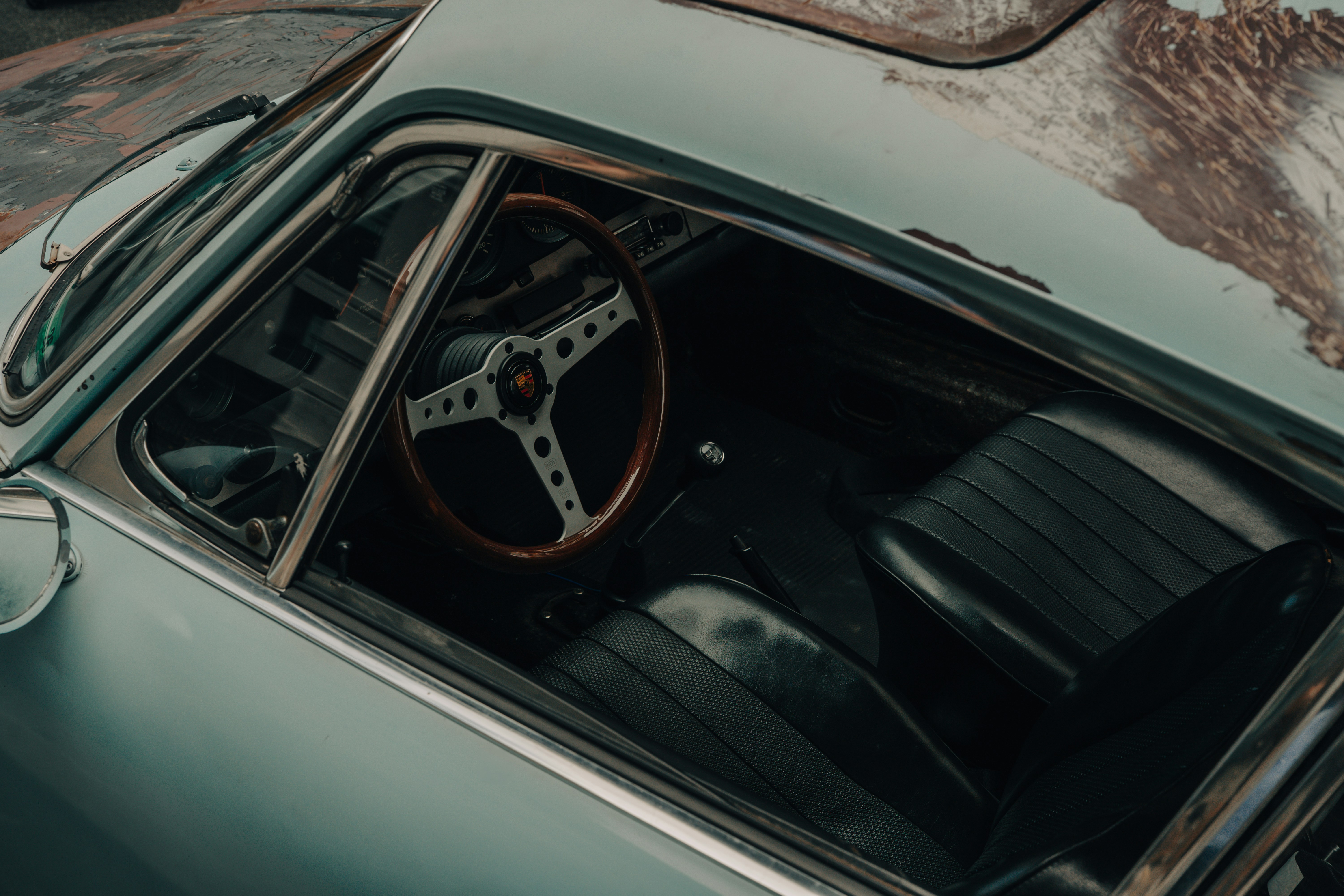 Inside an old car with a wooden steering wheel.