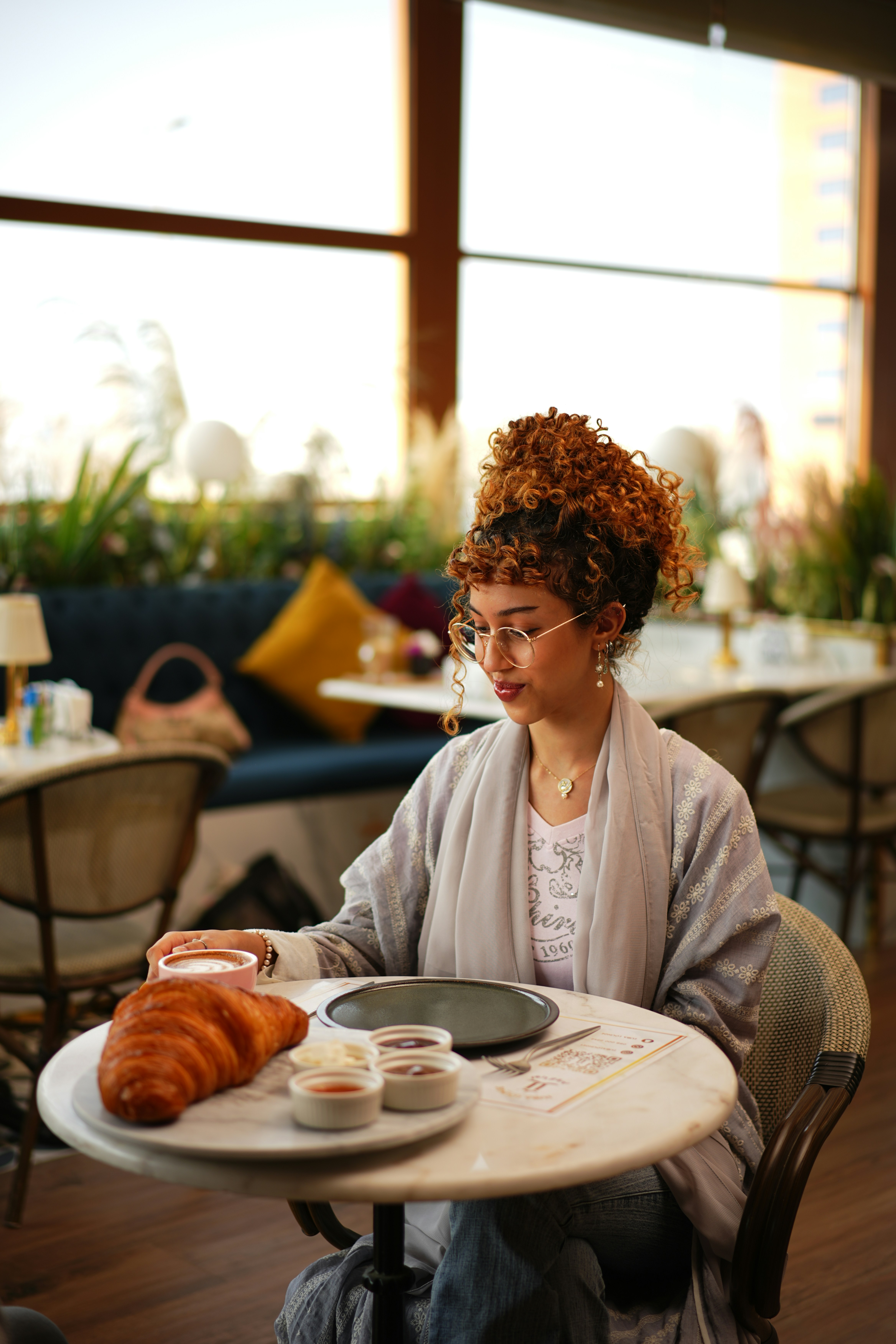 Woman is enjoying breakfast at a cafe.