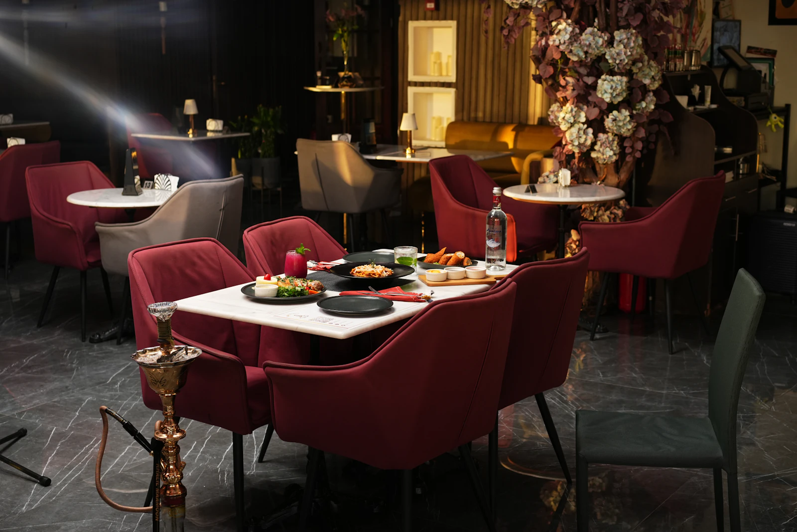 Upscale restaurant interior with marble tables and velvet seating