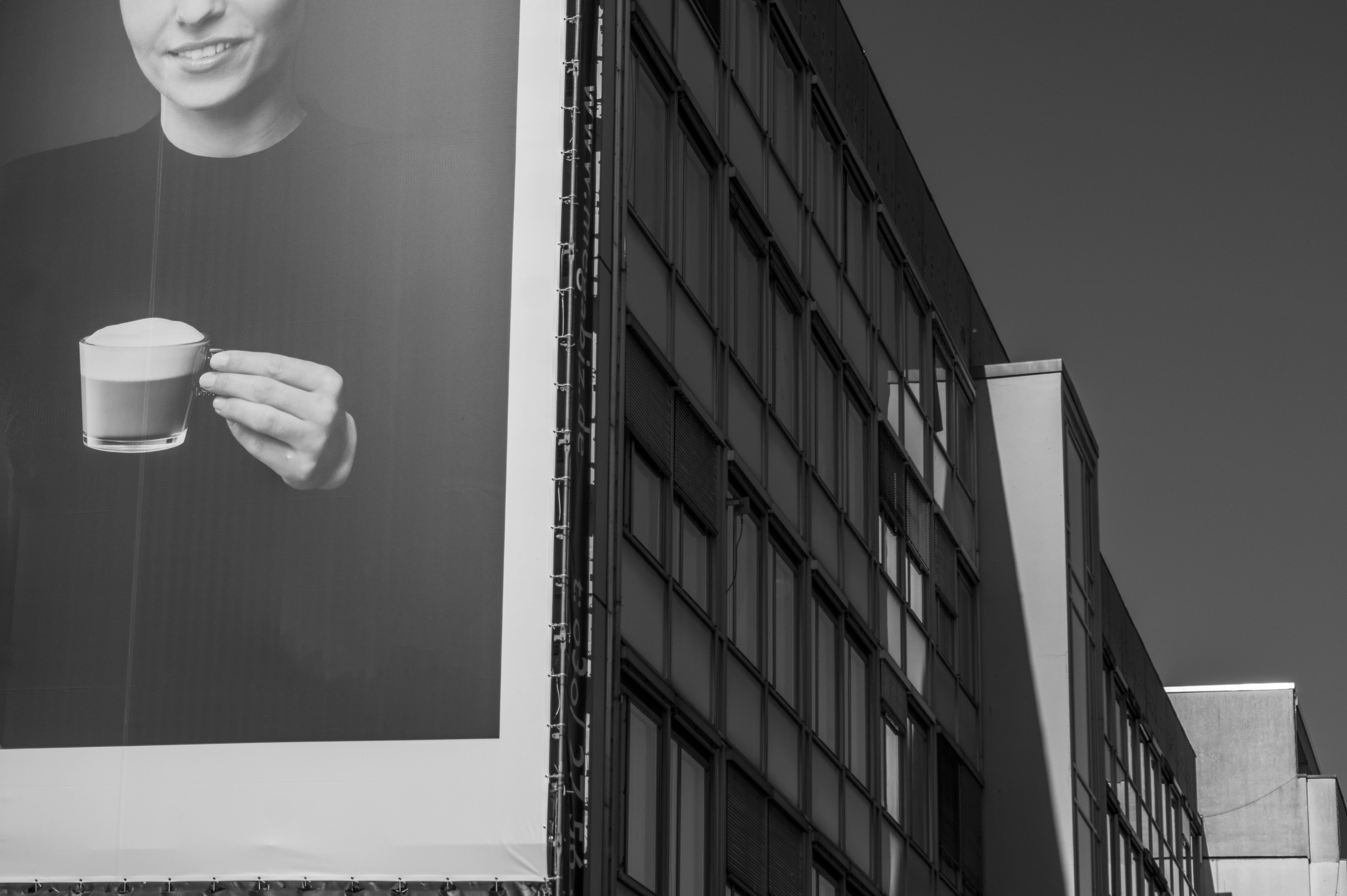 Building with advertisement of someone holding coffee