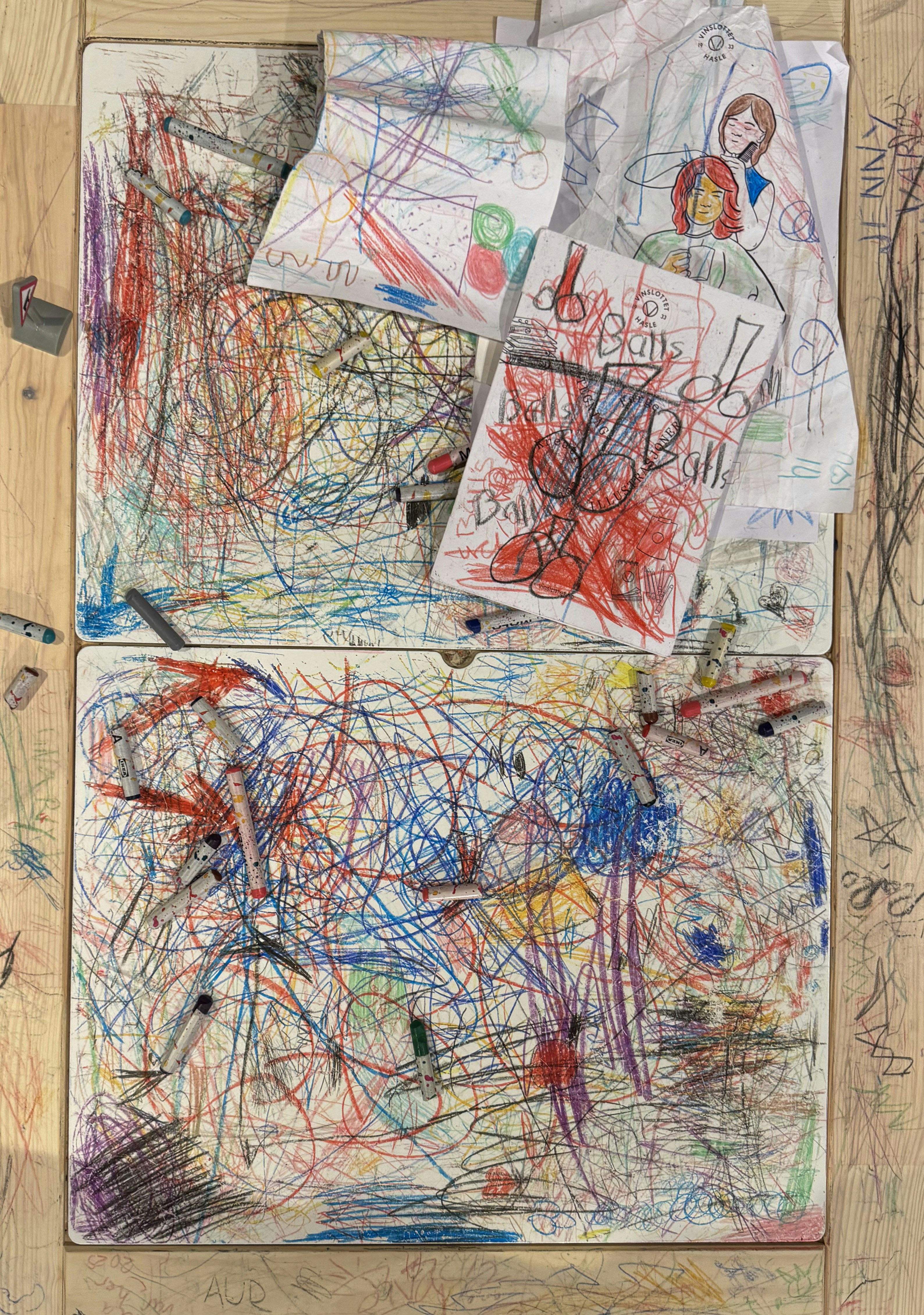 Colorful scribbles and drawings cover wooden surfaces.