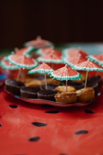 Cupcakes are decorated with watermelon-themed umbrellas.