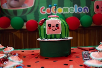 A cocomelon themed cake is displayed.