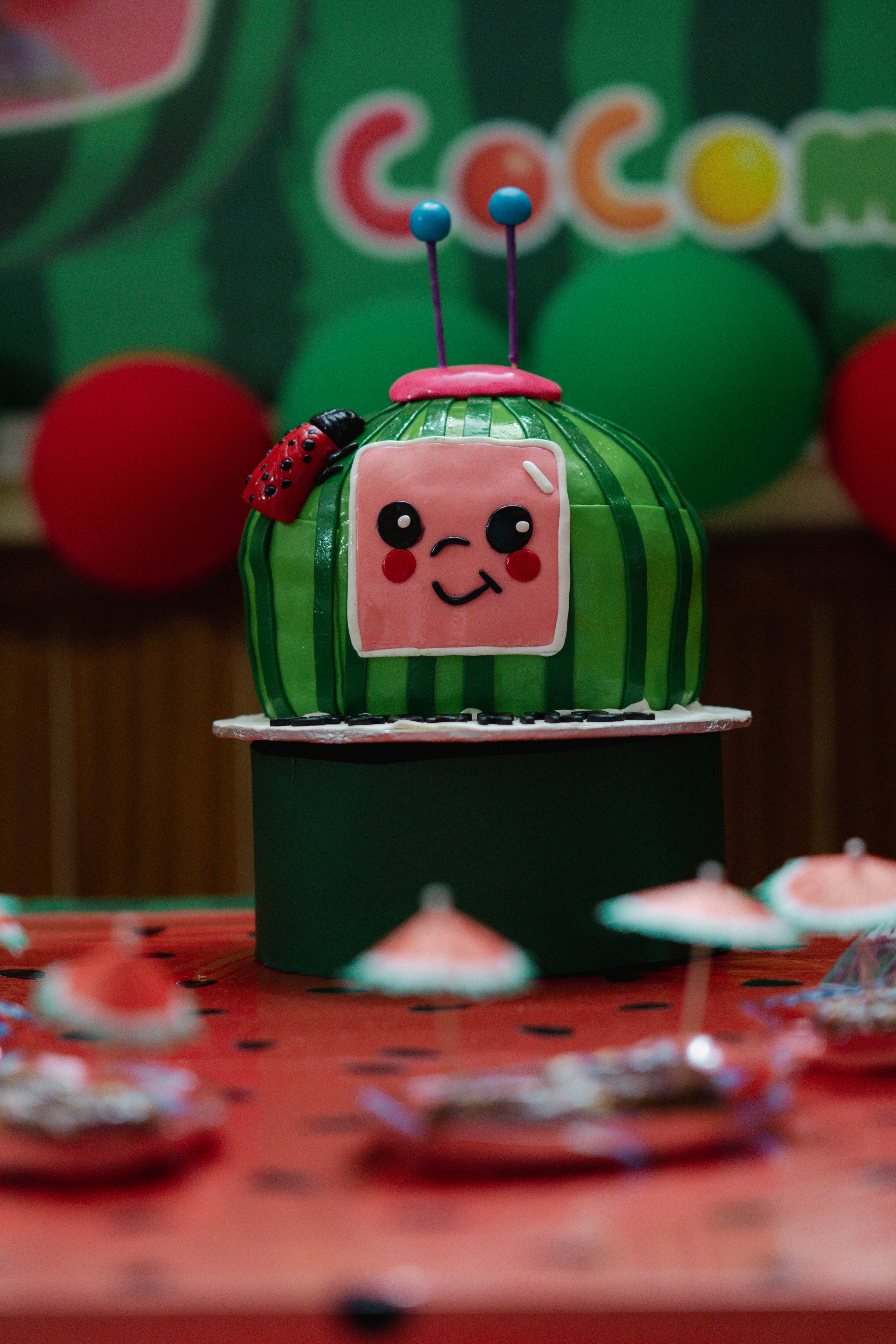 A colorful cocomelon cake is on display.