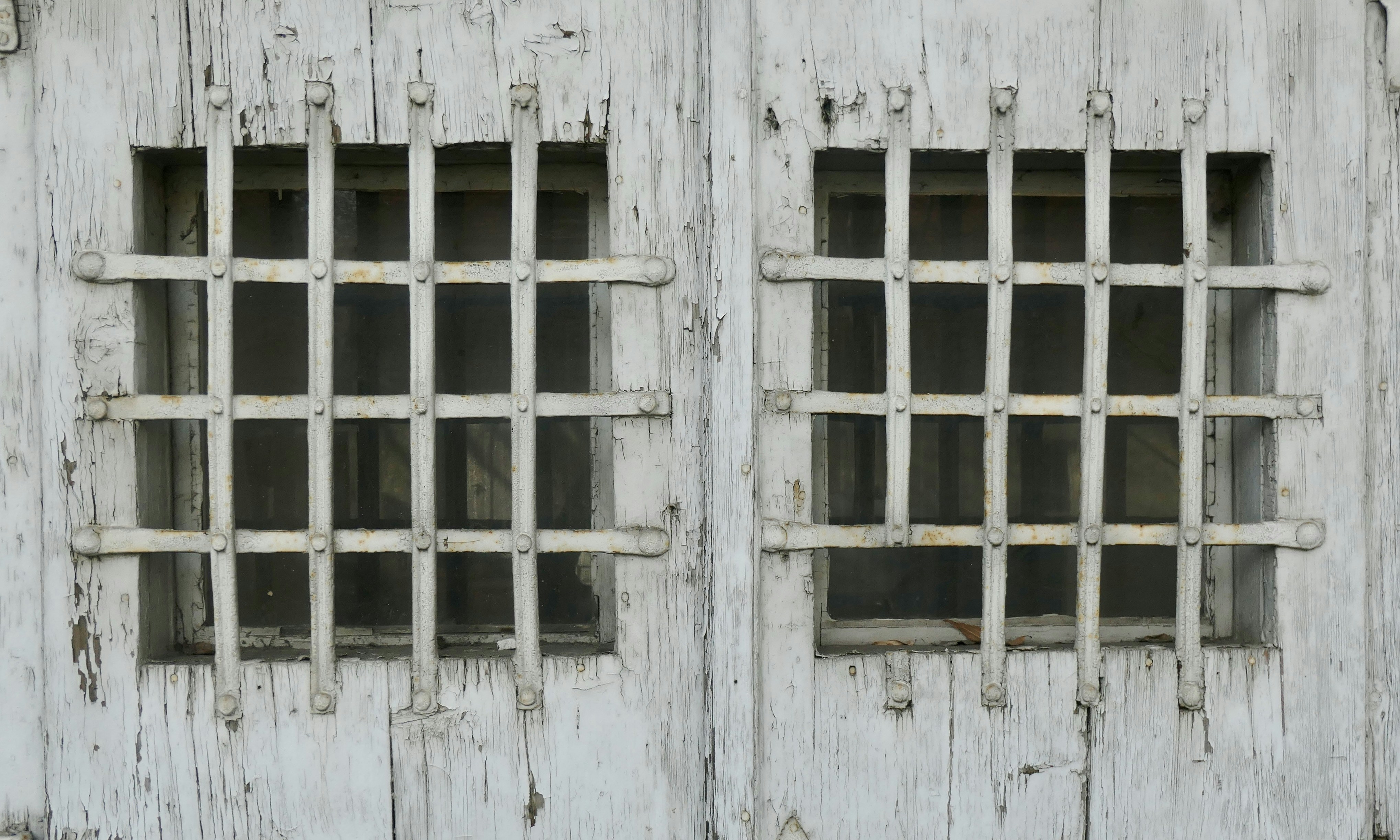 Two windows are covered with iron bars.