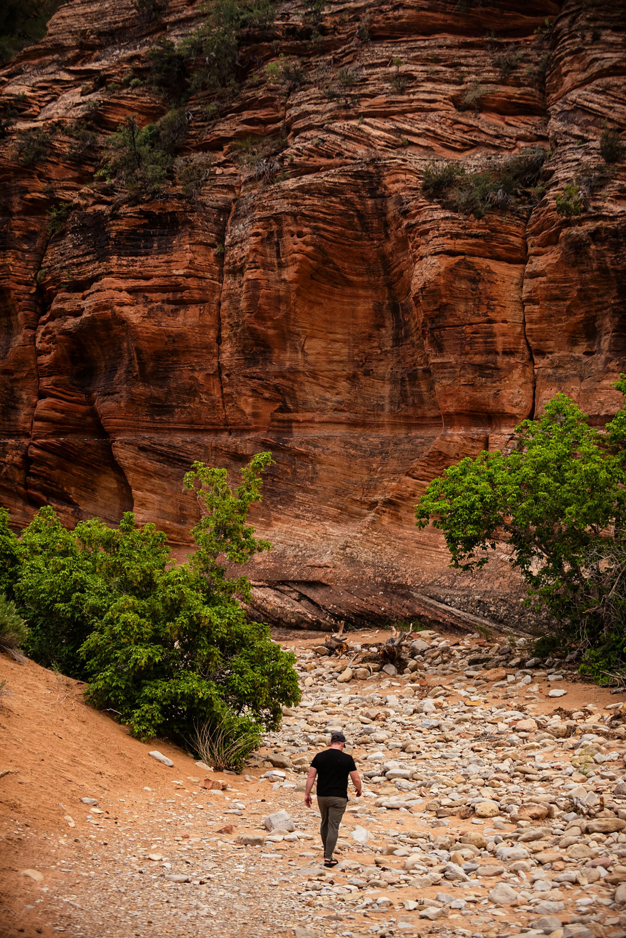 Uma pessoa caminha em direção à face rochosa de um desfiladeiro.